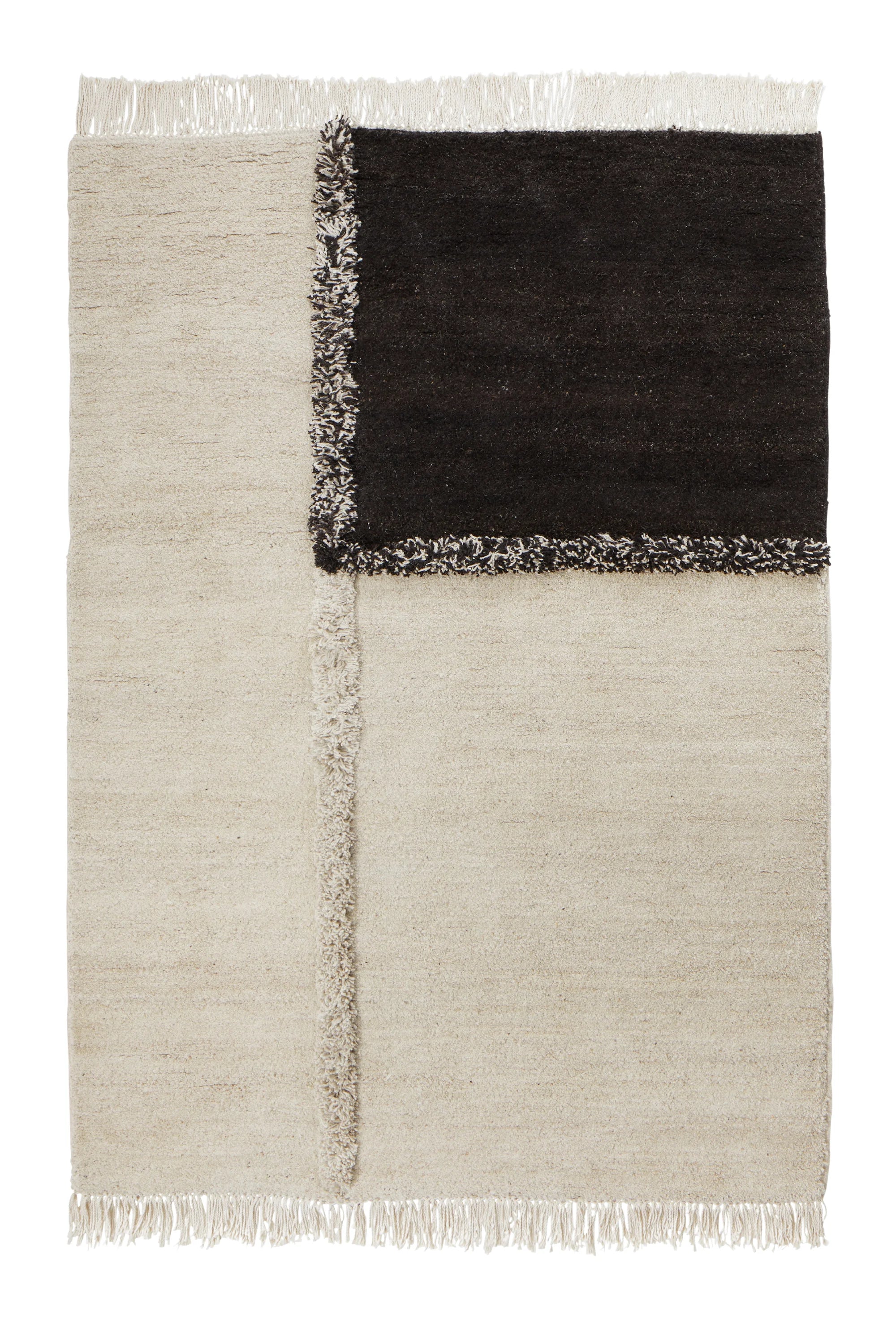 Sera Helsinki E-1027 Wool Rug, a hand-knotted area rug featuring a modern minimalist geometric design with contrasting textures. This contemporary rug showcases a dominant cream-colored natural wool base, accented by a deep dark brown rectangular block and intersecting textured lines in shaggy cream and black wool.