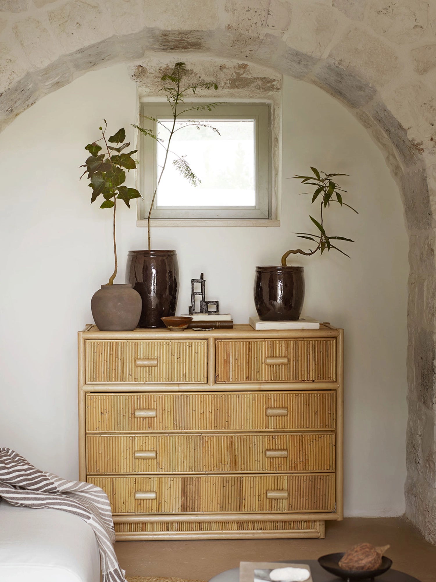 Tine K Palma Rattan Dresser, a natural rattan dresser featuring a warm light brown finish with vertically arranged rattan poles creating a distinctive textured facade on its six spacious drawers. This boho rattan chest of drawers offers ample storage for a coastal bedroom, organic modern living room, or a Mediterranean-inspired entryway.