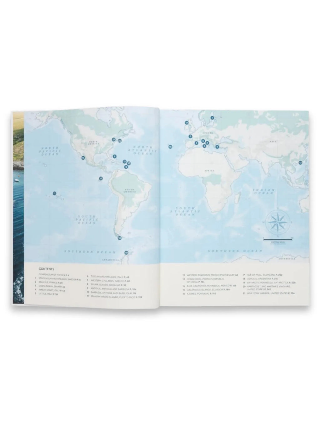 Book Sailing the Seas, an open hardcover book featuring a light teal and white world map spread with numbered blue pins indicating destinations. This beautiful travel book is perfect for inspiring wanderlust in sailing enthusiasts and global adventurers.