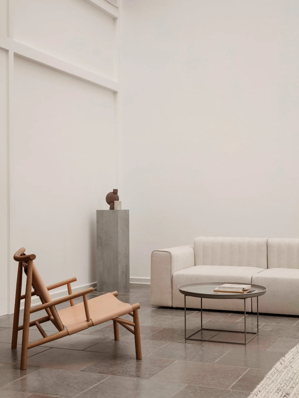 NORR11 Samurai Chair, a stylish lounge chair featuring a natural wood frame and elegant tan leather sling seat. This durable and modern piece is perfect for creating a chic and comfortable seating area for design-conscious individuals.