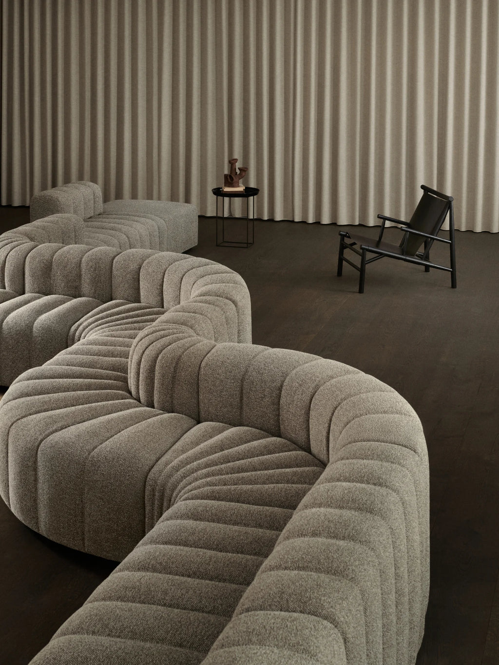 NORR11 Samurai Chair, a modern, elegant lounge chair in textured grey upholstery with a sleek black frame. This luxury seating option is perfect for stylish living spaces and discerning homeowners.
