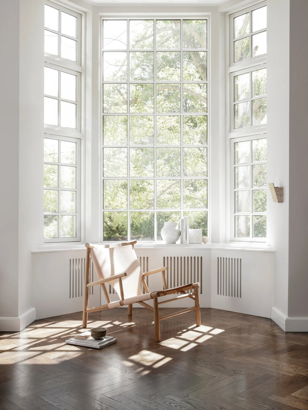 NORR11 Samurai Chair, a modern lounge chair with a natural light wooden frame and cream canvas seat. A stylish, elegant piece for any contemporary living space.