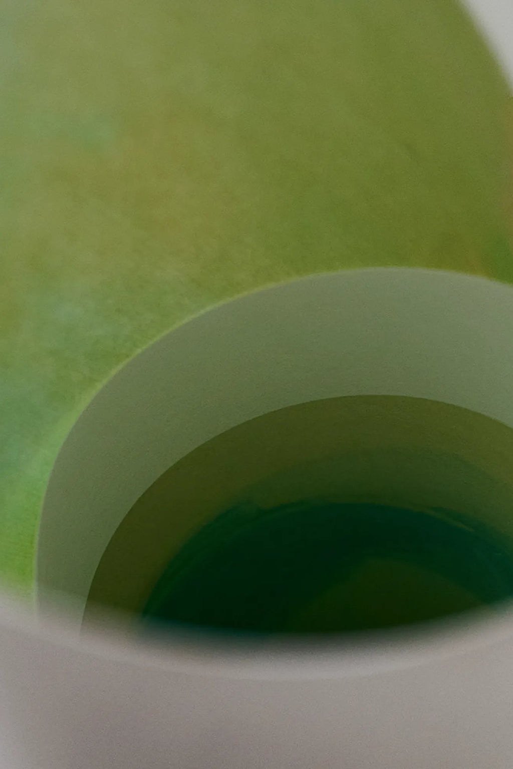The Poster Club Carré, an abstract art print featuring a soothing gradient of organic green tones, transitioning from soft lime green to deep forest green in concentric curved forms. This contemporary minimalist poster, with its subtle paper texture, creates a calming visual impact. Ideal for modern living rooms, Scandinavian bedrooms, or as a striking addition to a gallery wall.