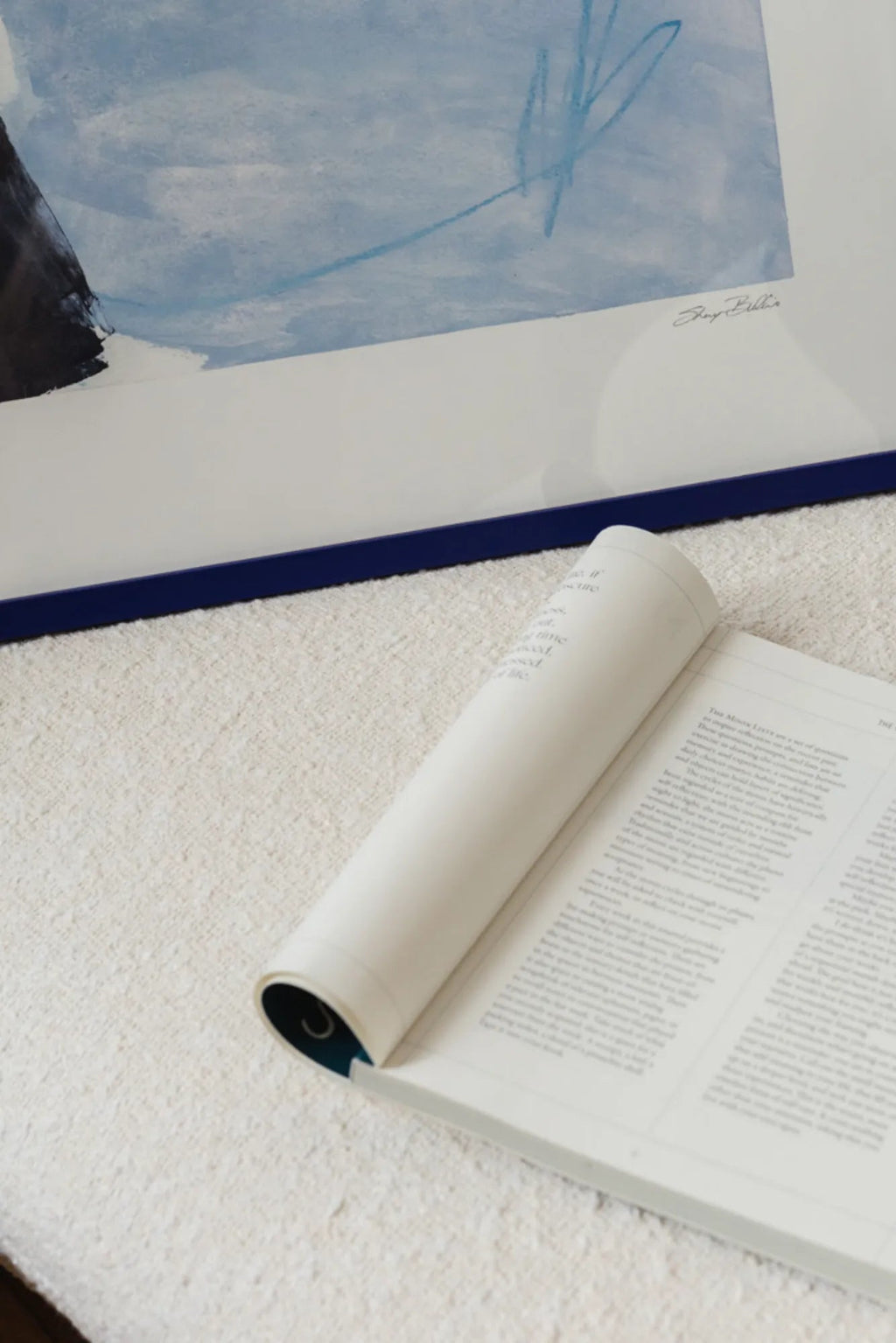 The Poster Club Kevät Saapuu, an abstract art print featuring soft light blue watercolor-like washes and a bold black brushstroke, accented with delicate light blue lines, set against a.