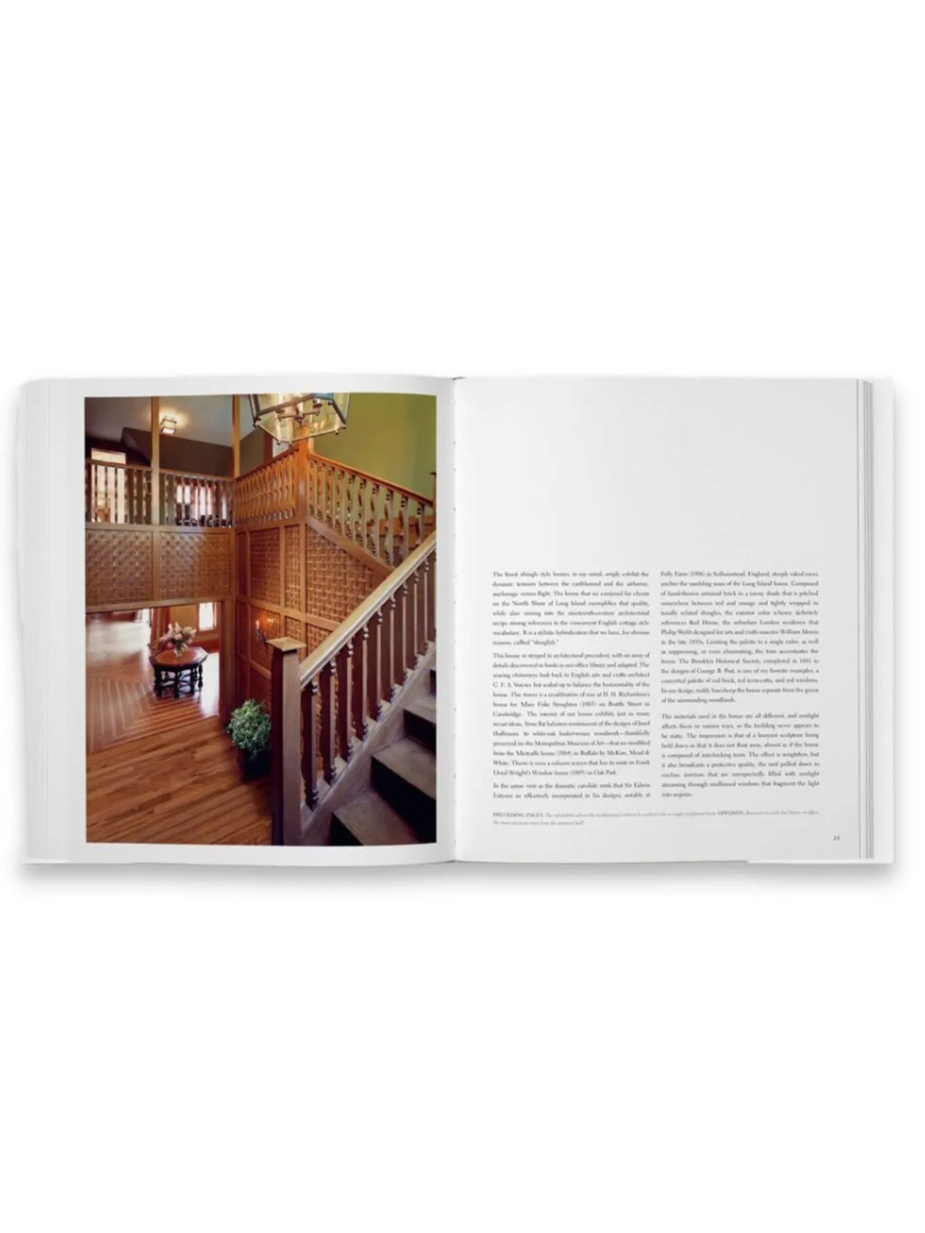 Book Shingle and Stone, an open coffee table book displaying a detailed image of a grand, multi-level wooden staircase and entryway with rich brown wood tones and intricate latticework. This premium architectural book offers inspiration and visual delight for interior design enthusiasts, architects, and luxury home decorators.