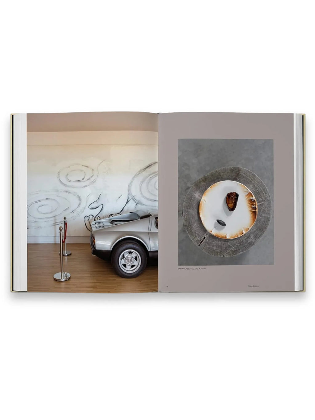 Book Slow Food, Fast Cars, an open hardcover coffee table book displaying a silver vintage car exhibit on the left page and an artfully plated dish on a rustic wooden slice on the right page. This unique culinary and automotive photography book is perfect for enthusiasts of luxury lifestyle, fine dining, and classic car culture.