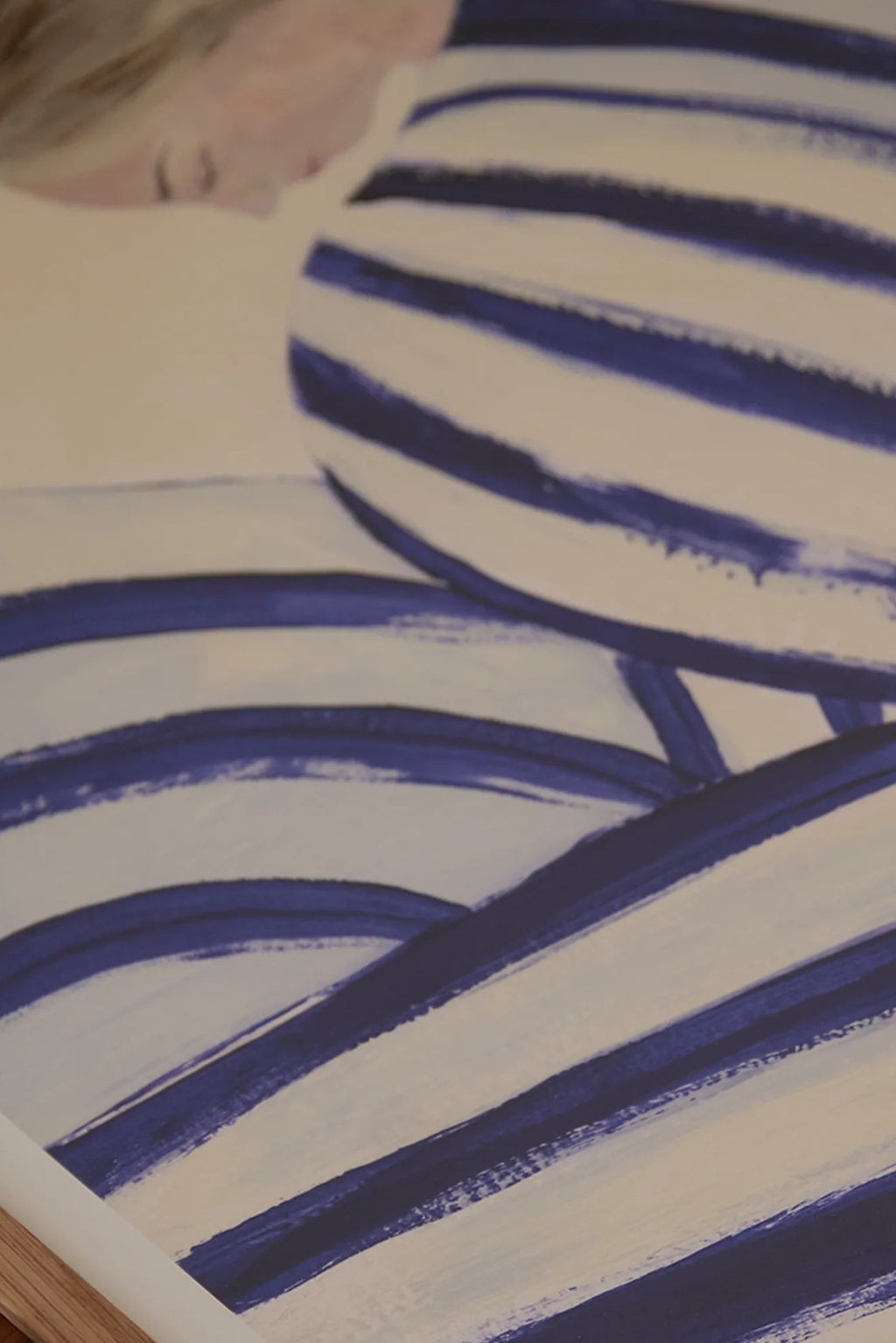 The Poster Club Blue Stripe At Concorde, an abstract art print featuring bold, hand-painted deep blue brushstroke stripes against a soft cream background, with a subtle hint of a human figure. This contemporary and minimalist poster brings a fresh, modern aesthetic, perfect as striking wall art for a living room, bedroom, or gallery wall.