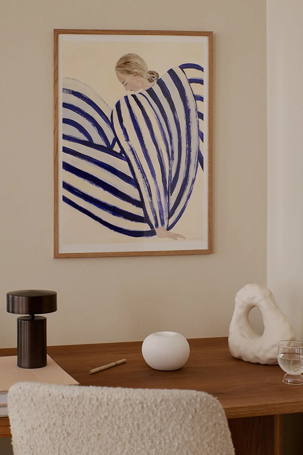 The Poster Club Blue Stripe At Concorde, a contemporary abstract figurative art print featuring a woman rendered in bold royal blue and cream brushstroke stripes with a hand-painted texture, framed in a light natural oak frame with a crisp white mat. Ideal as modern wall art for Scandinavian living rooms, minimalist bedrooms, or a stylish home office gallery wall.