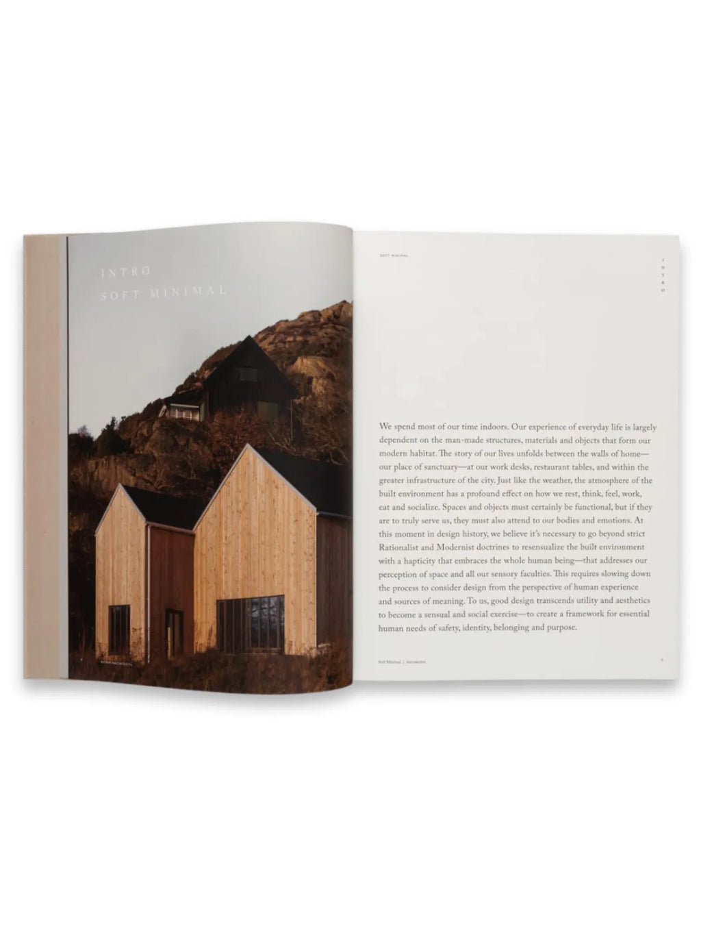 Book Soft Minimal – By Norm Architects, an open architectural design book featuring a minimalist wooden house nestled into a rocky, mountainous landscape on the left page, with introductory text on the right. This aesthetic coffee table book is perfect for architecture enthusiasts and design professionals seeking inspiration.