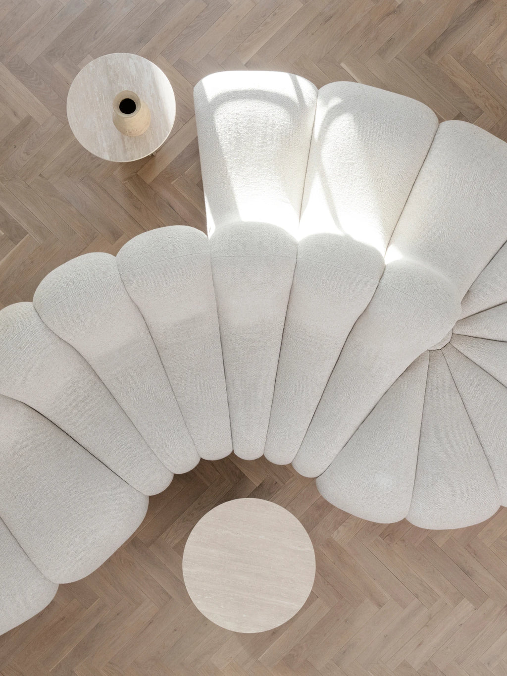 NORR11 Soho Side Table, a round organic modern side table crafted from light beige natural travertine stone with subtle veining and a smooth, matte finish. Its minimalist brutalist-inspired design makes it an ideal contemporary accent for living rooms, bedrooms, or as a stylish bedside table.