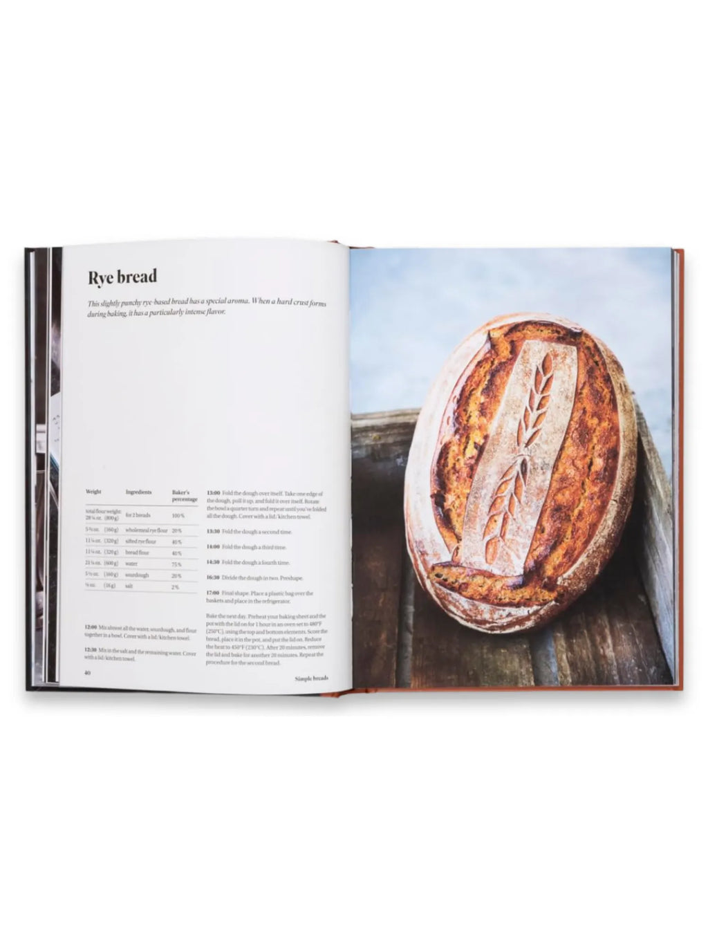 Book Sourdough for All, open cookbook page displaying a detailed "Rye bread" recipe with ingredients, instructions, and a beautiful image of a perfectly baked, rustic sourdough loaf with a decorative wheat score. This essential baking guide is perfect for aspiring home bakers and culinary enthusiasts eager to master sourdough techniques.