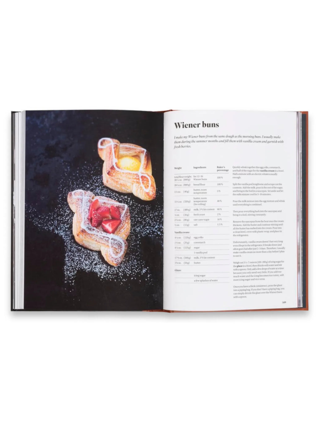 Book Sourdough for All, open cookbook displaying a recipe for "Wiener Buns" with an appetizing photo of two golden-brown pastries, one with fresh strawberries and the other with a yellow custard filling, both dusted with powdered sugar and drizzled with white icing, set against a dark background. This premium baking and dessert cookbook is perfect for home bakers seeking new, delightful recipes and culinary inspiration.