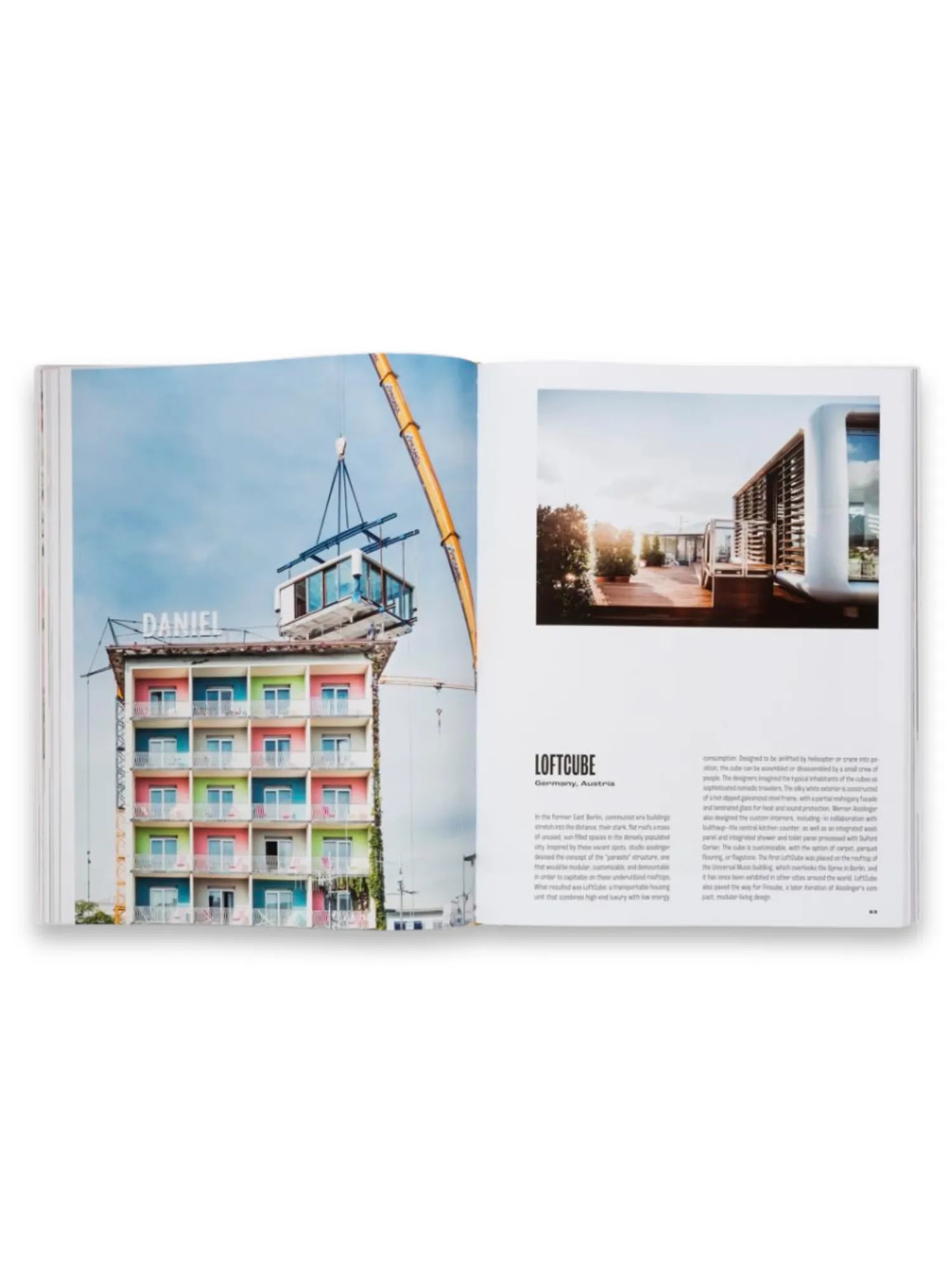 Book Spatial Storytelling, an open book displaying a colorful building with a modular unit being craned onto its roof on the left page, and a modern rooftop living space with text about "LOFTCUBE" on the right. This comprehensive book offers design inspiration and architectural insights for professionals and enthusiasts alike.