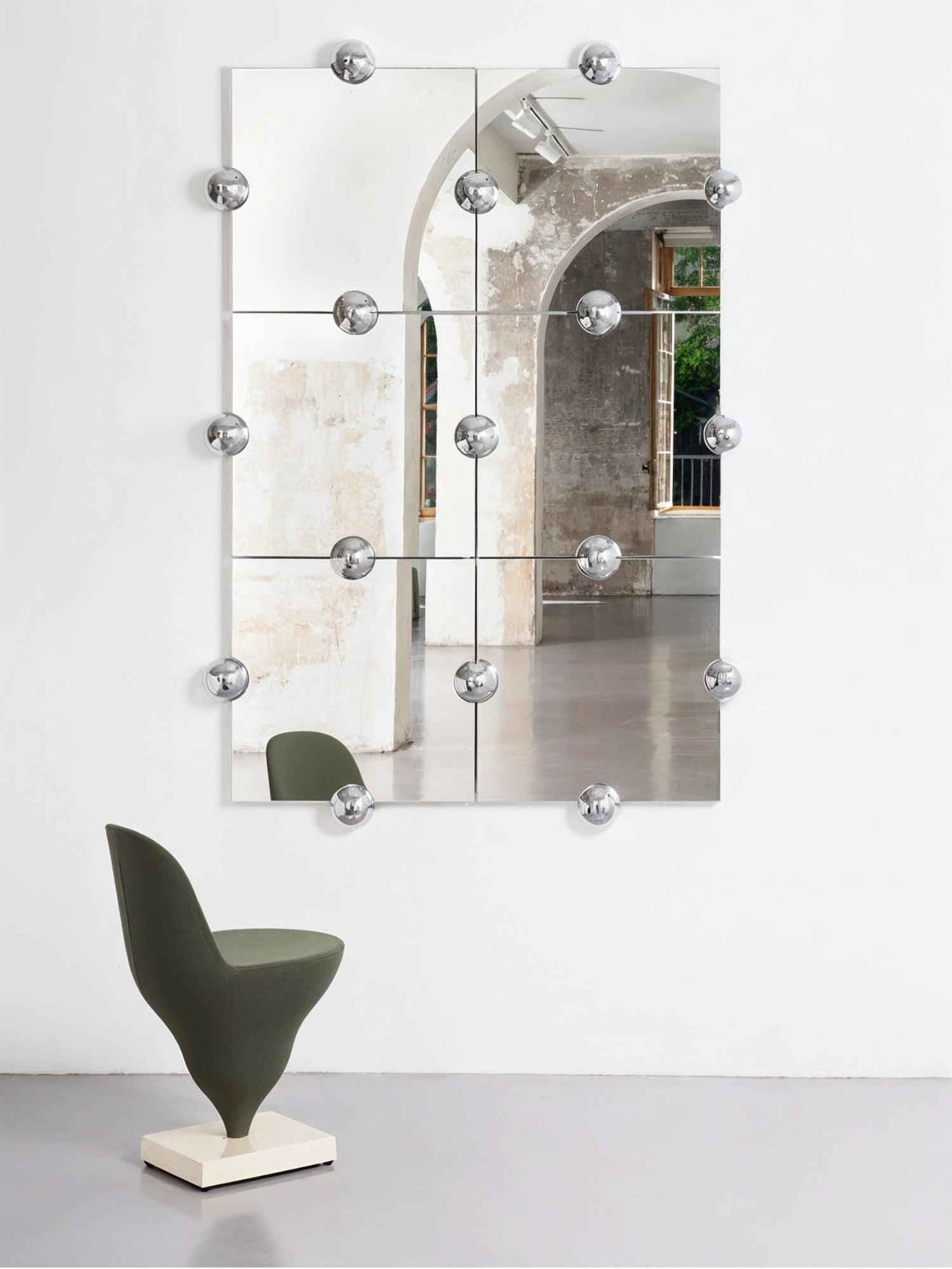 Moustache Sphera Crystal Palace L Vertical Mirror, a large, elegant modular mirror with six square panels and chrome spherical fasteners, reflecting an industrial-chic interior and a green chair.