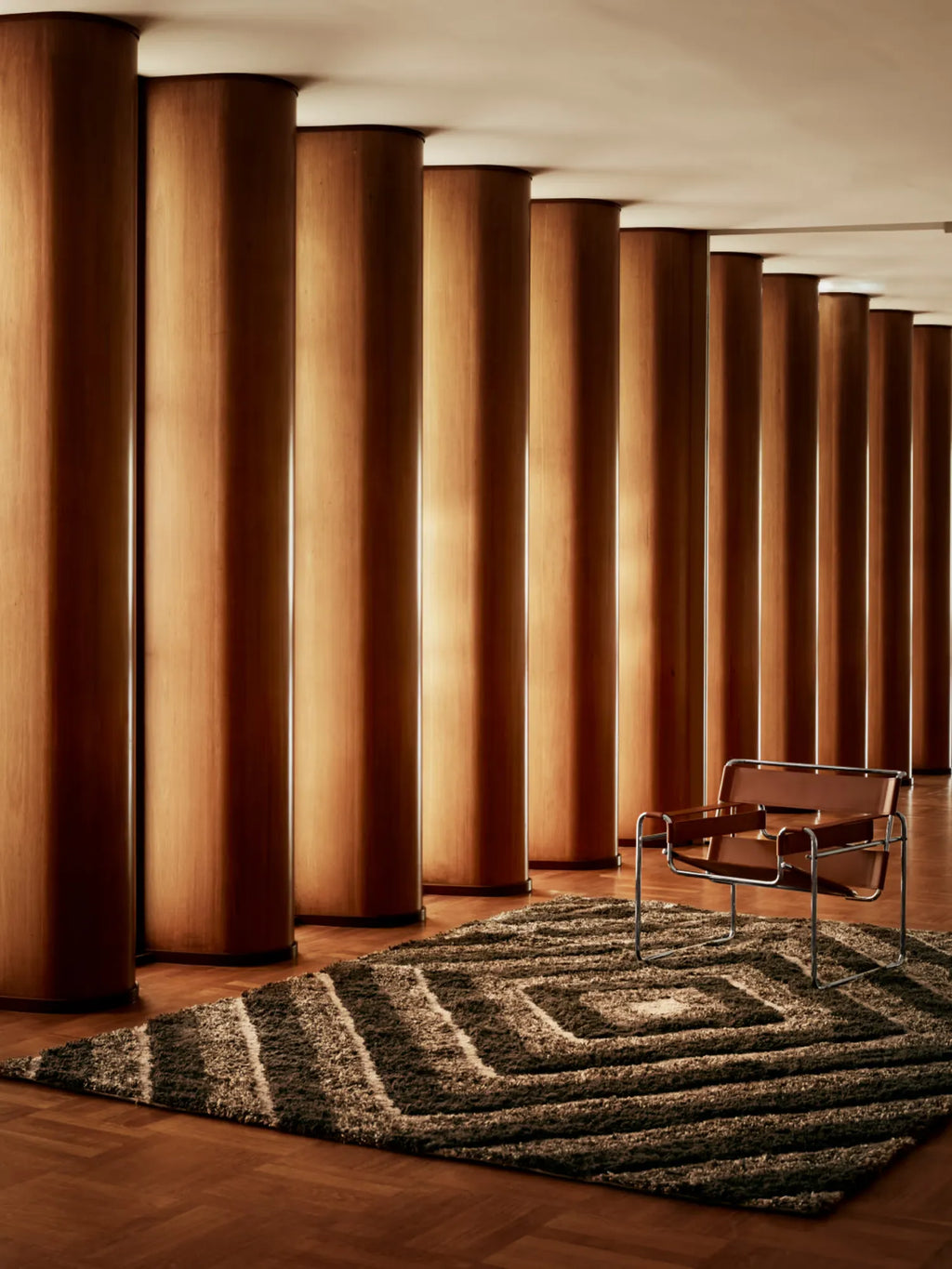 Tinted Objects Stenborg Wool Rug, a luxurious deep pile area rug in dark brown and beige with a contemporary geometric square pattern. This premium wool rug is ideal for adding warmth and modern style to living rooms or offices.
