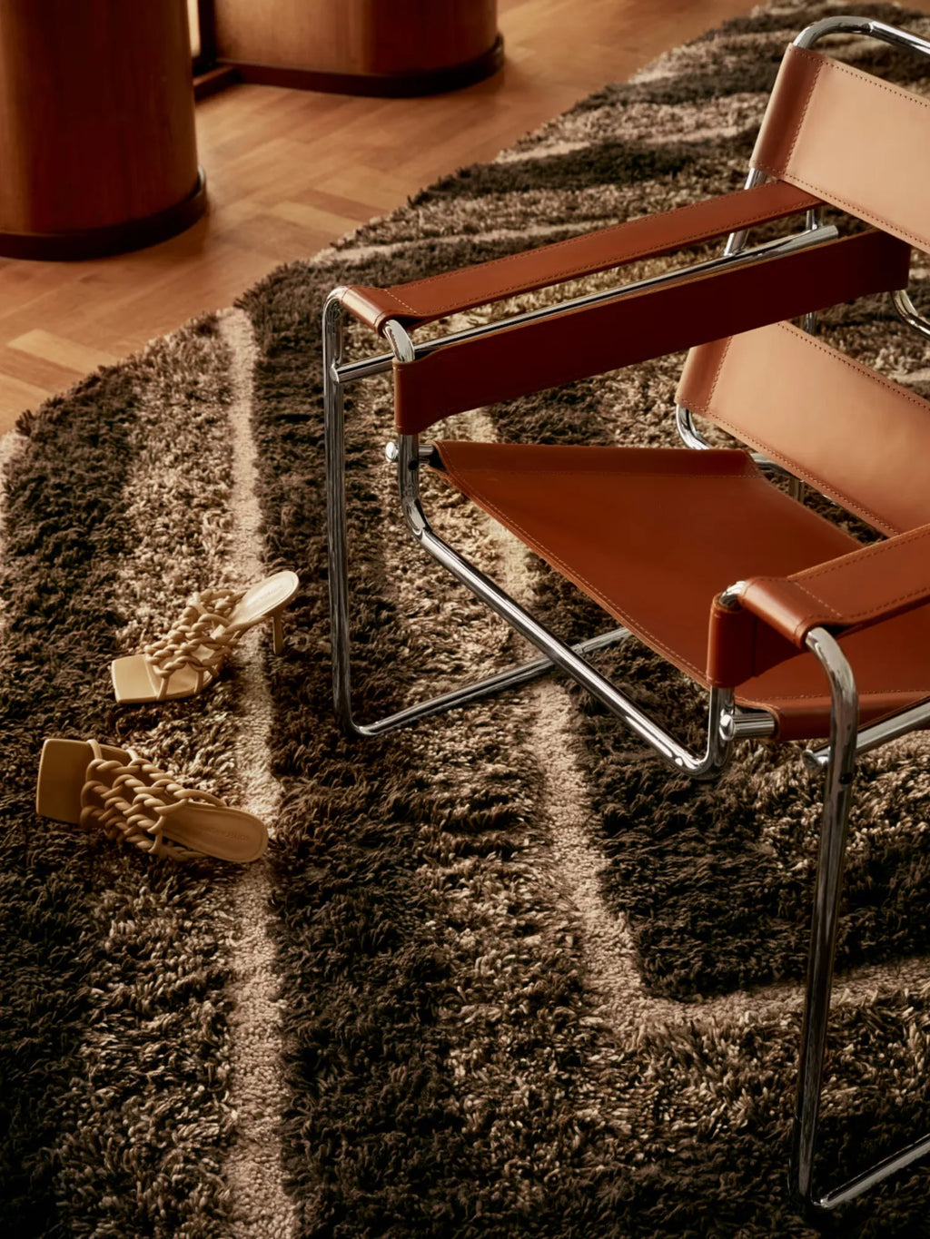Tinted Objects Stenborg Wool Rug, a luxurious deep pile shag rug with an organic brown and beige striped pattern. This high-quality floor covering is perfect for adding warmth and sophisticated texture to any modern living space or bedroom.