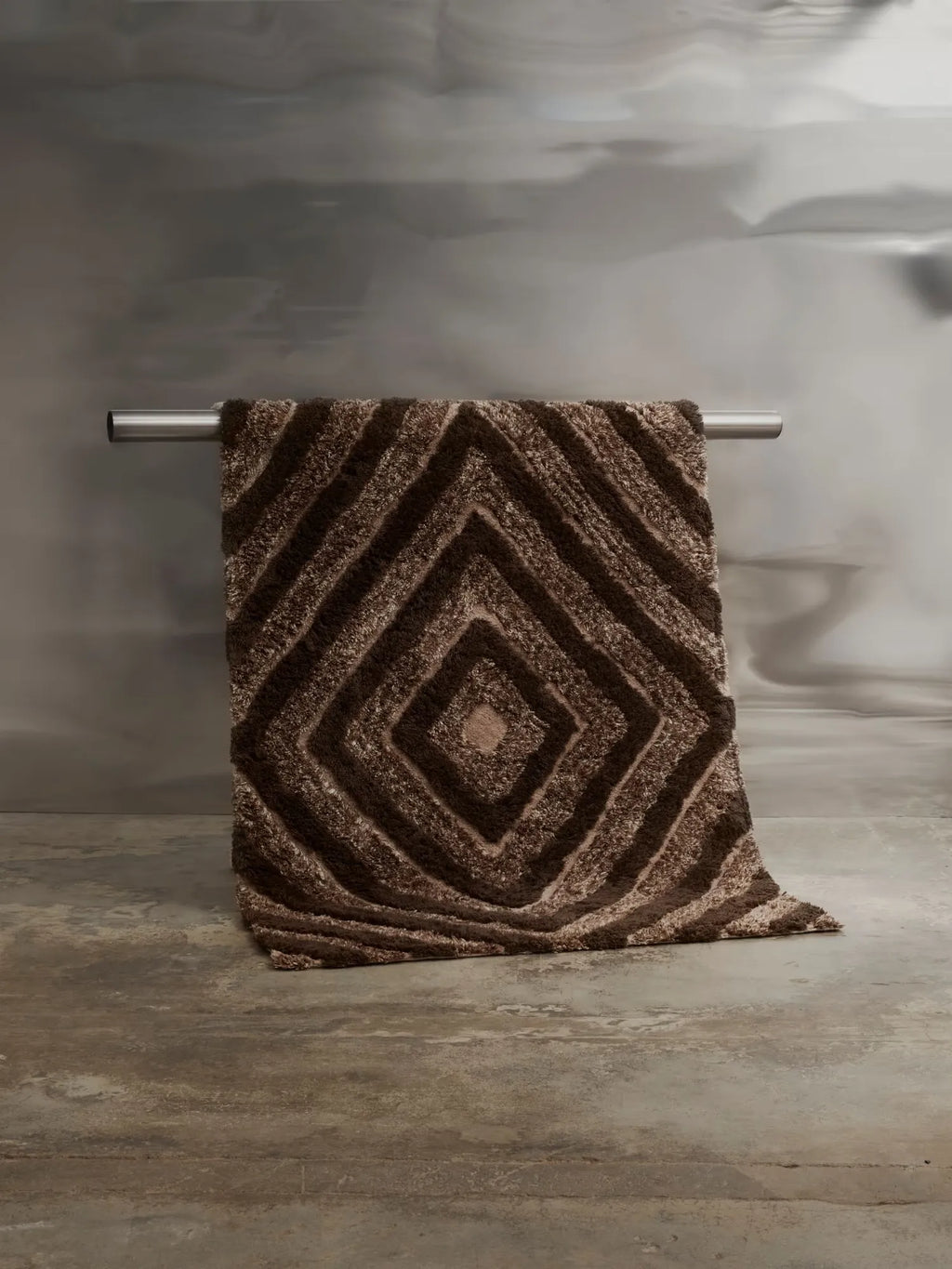 Tinted Objects Stenborg Wool Rug, a plush, shaggy brown and beige rug with a distinct geometric diamond pattern. This cozy, durable wool rug adds warmth and modern style to any living space.