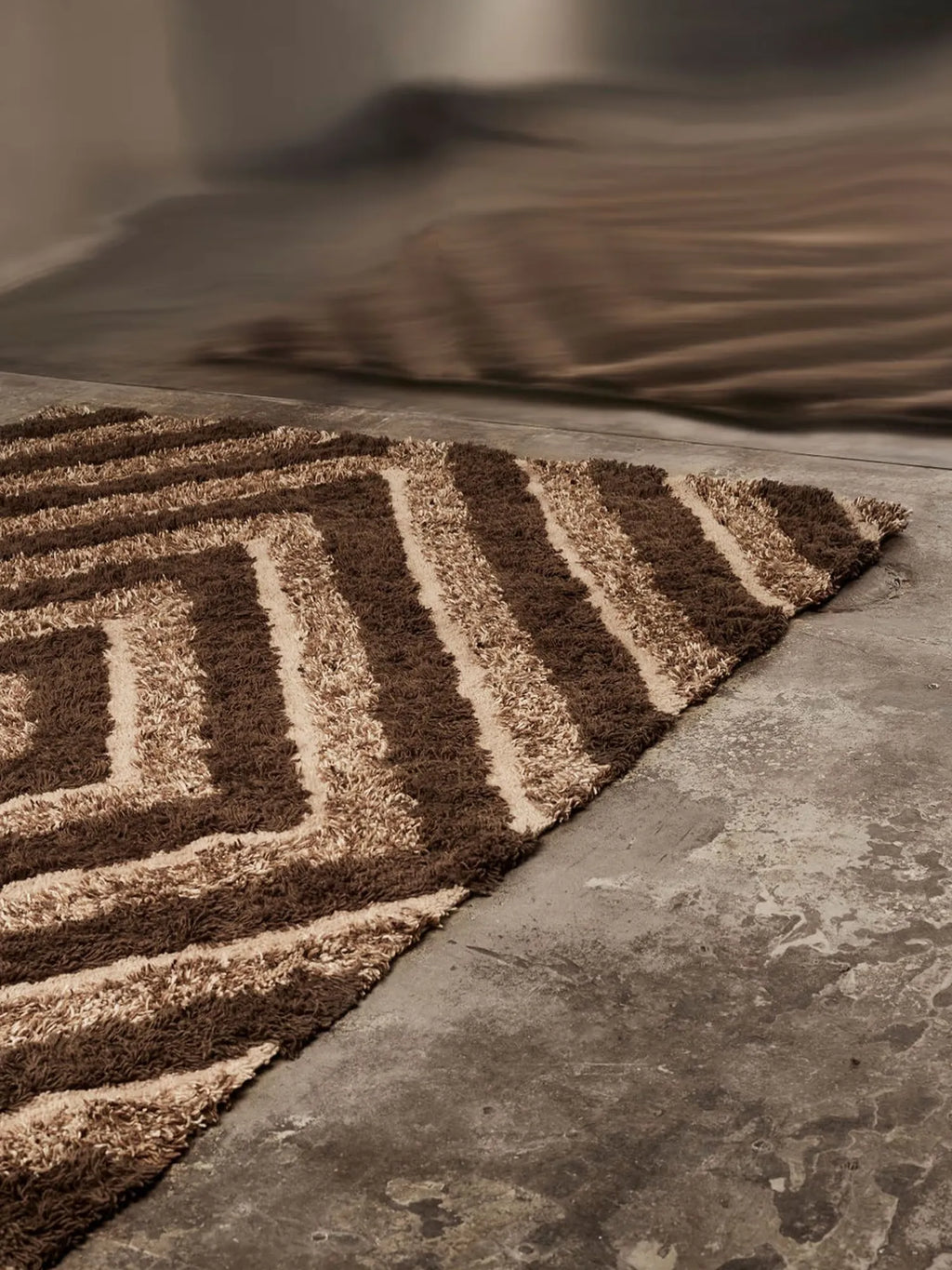 Tinted Objects Stenborg Wool Rug, a luxurious shaggy area rug with a bold brown and beige abstract geometric pattern. This stylish and soft wool rug adds warmth and modern flair to any living space or bedroom.