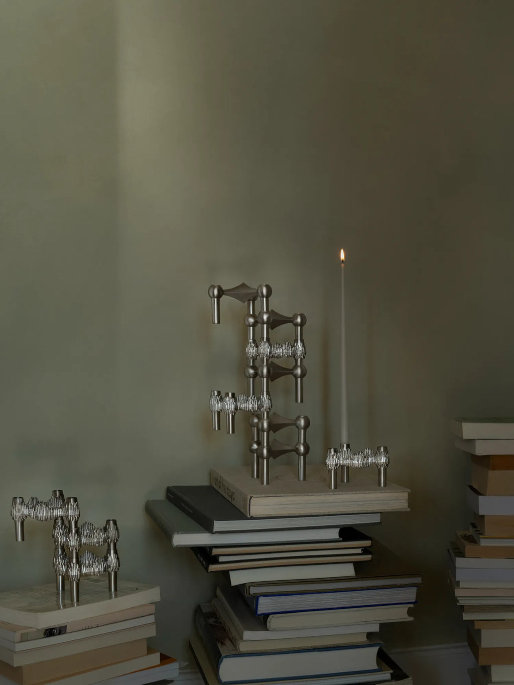 Stoff Nagel Quist Candle Holder, an iconic modular candle holder crafted from polished chrome-plated metal with an interlocking, stackable sculptural design, showcasing a distinct brutalist and mid-century modern aesthetic. This versatile silver metal candle holder is perfect for creating dynamic displays as a contemporary dining table centerpiece, stylish shelf styling, or unique living room decor.
