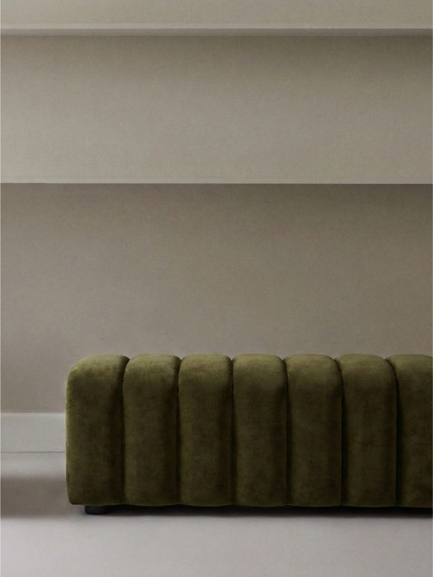 NORR11 Studio Bench in Alpaca 1110 fabric, a luxurious olive green velvet with a plush, ribbed texture, elegantly placed in a minimalist room setting.