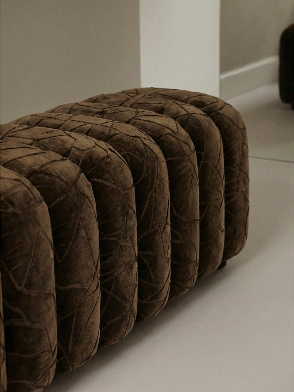 NORR11 Studio Bench. Detailed close-up of the rich brown velvet upholstered bench, showcasing its unique quilted pattern and luxurious texture, adding a touch of sophistication to any space.