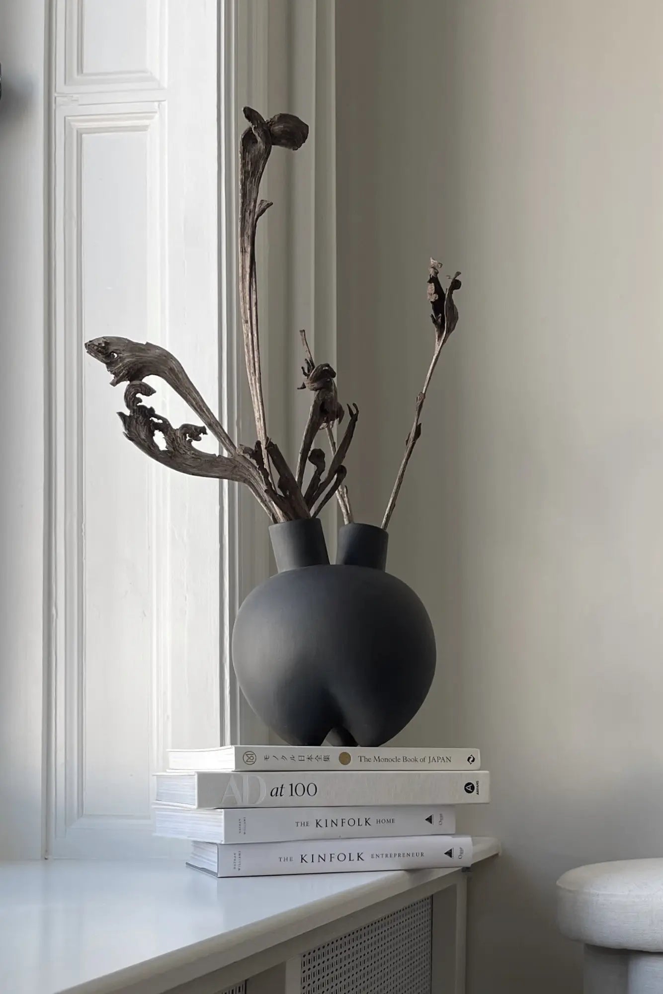 Hand-painted ceramic vase with intricate, horn-shaped handles in natural tones