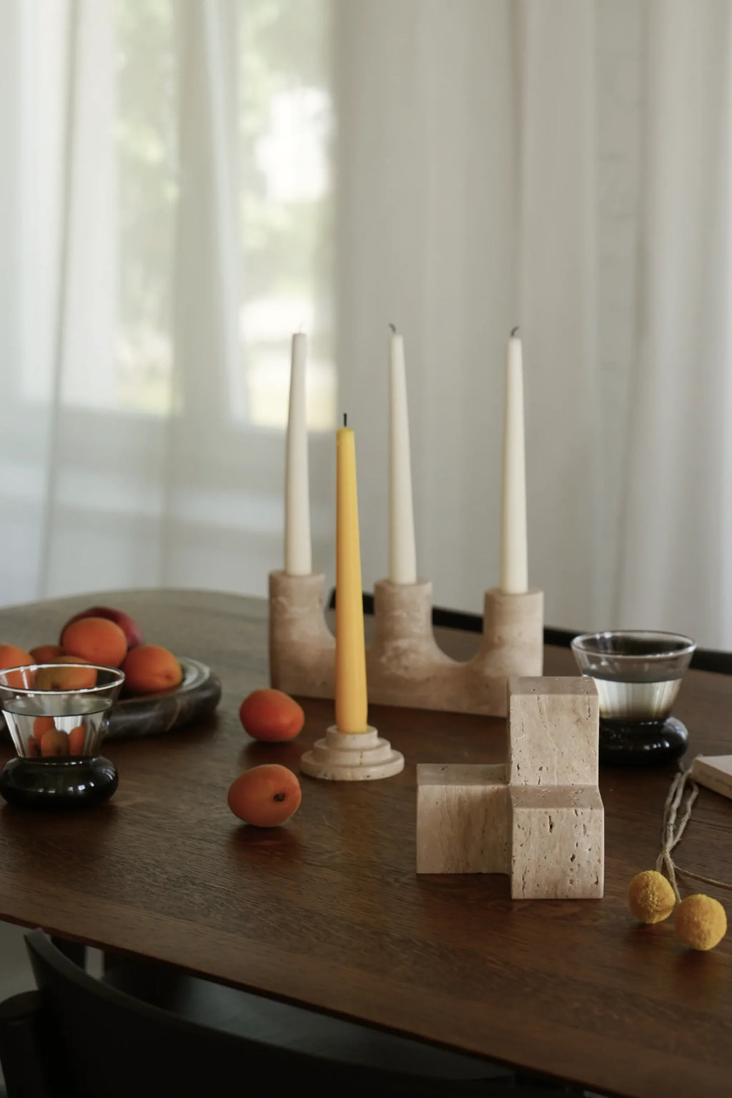 TAMO Tero Travertine Bookend, a premium natural beige travertine rectangular L-shaped bookend displaying its porous texture, arranged on a dark wooden table in a lifestyle setting. An authentic addition to any sophisticated home office.