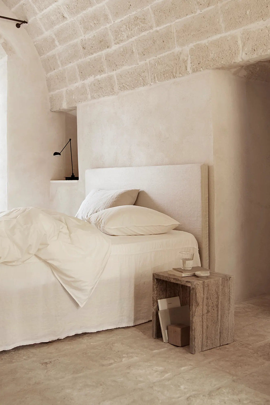 Tine K Cube Travertine Table, a solid natural travertine stone side table with a minimalist block shape and warm, earthy beige and brown tones. Its porous, textured surface and distinct veining embody an organic modern design aesthetic.