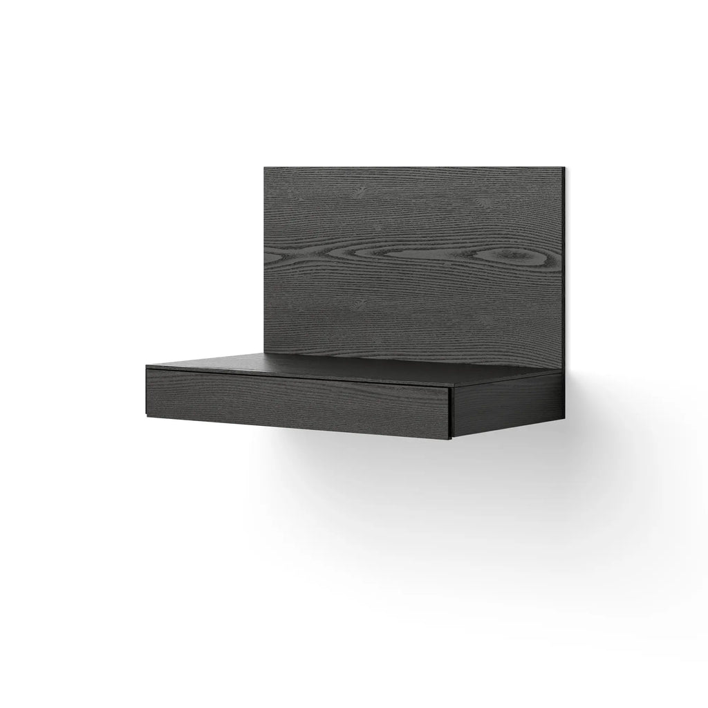 New Works Tana Wall Mounted Desk, a sleek modern minimalist floating desk crafted from dark grey stained wood with a prominent wood grain texture and a single integrated drawer.