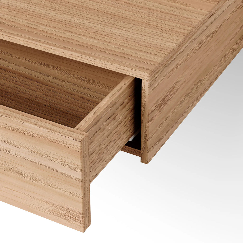 New Works Tana Wall Mounted Desk, a modern minimalist floating desk crafted from natural solid oak wood with a visible grain texture and a single integrated drawer, showcasing clean Scandinavian lines. Ideal as a compact home office desk or a stylish console table for small spaces and contemporary interiors.