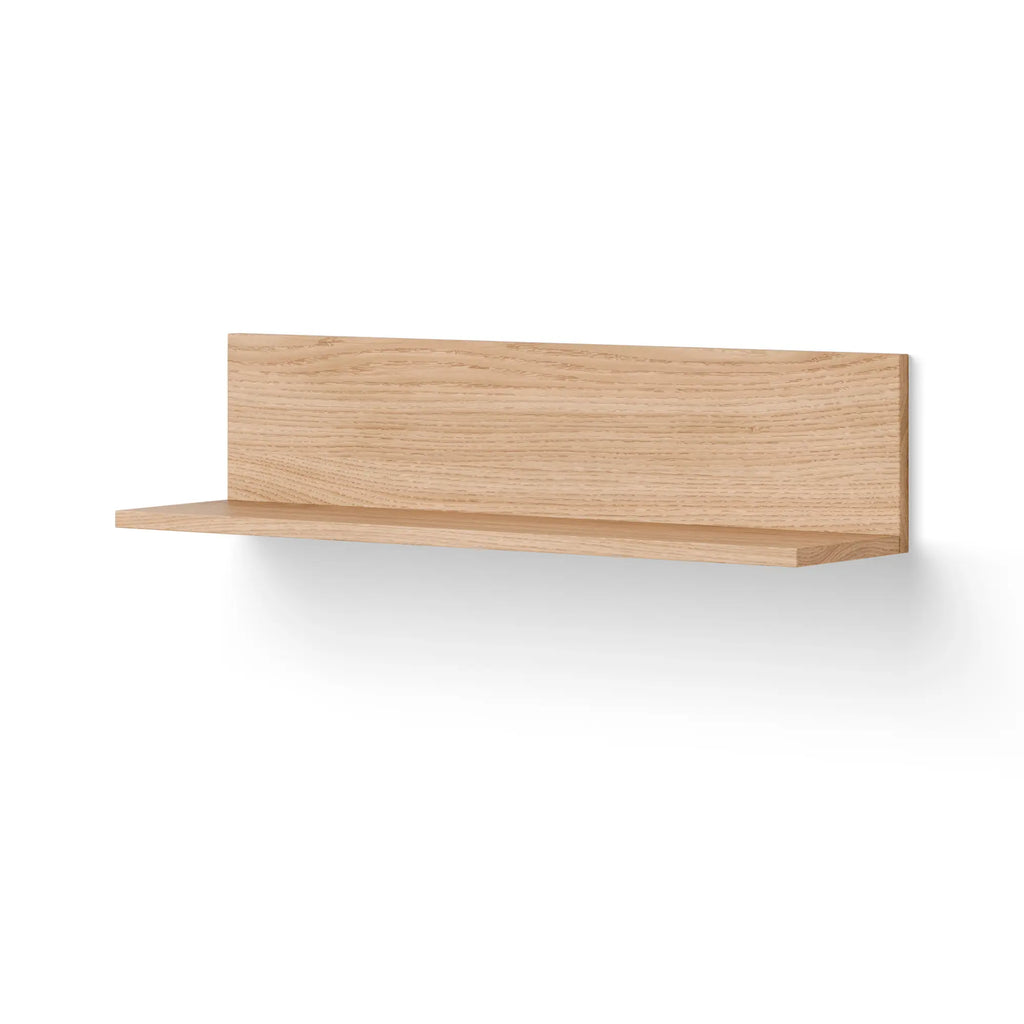 New Works Tana Wall Shelf, a modern minimalist solid oak wall shelf in a light natural wood finish, featuring a clean rectangular design with a subtle grooved front edge and a sleek back panel for secure wall mounting. Perfect for Scandinavian, contemporary, or Japandi interiors, ideal as a versatile display shelf for living rooms, bedrooms, or home offices.