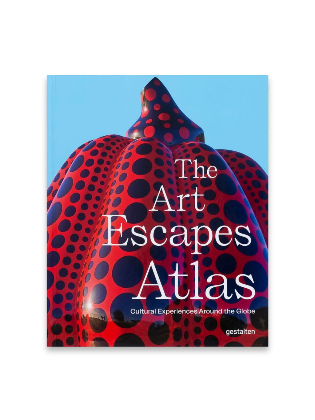 Book The Art Escapes Atlas, featuring a vibrant red-and-black polka-dotted sculpture resembling a pumpkin against a bright blue sky. This modern art travel guide is perfect for cultural enthusiasts and art history lovers seeking inspiring global experiences.