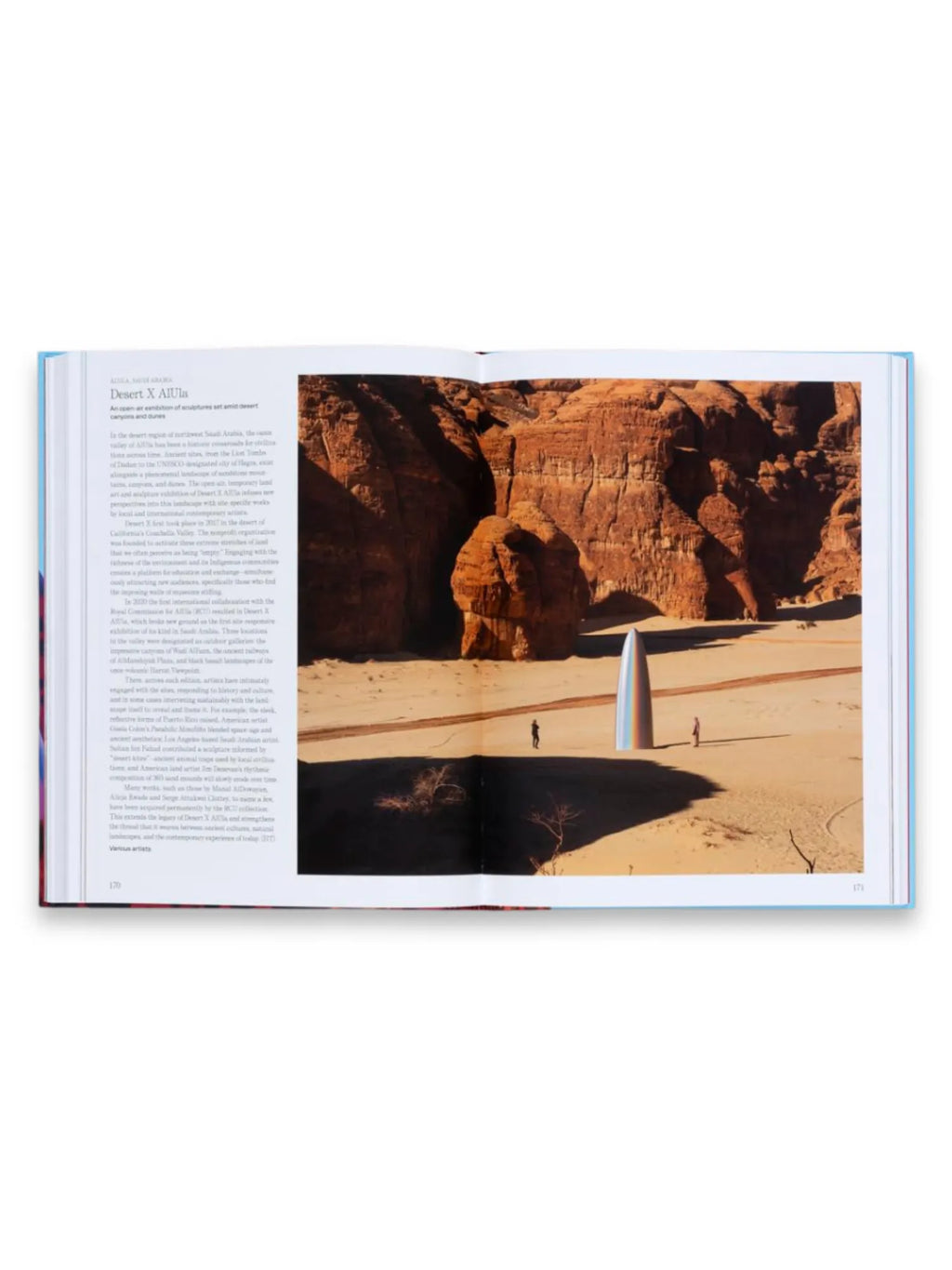 Book The Art Escapes Atlas, featuring a vibrant, open-page spread displaying a photograph of a desert landscape with towering red rock formations and a unique, rainbow-colored conical sculpture. This premium coffee table book offers a visually stunning and informative journey for art and travel enthusiasts.