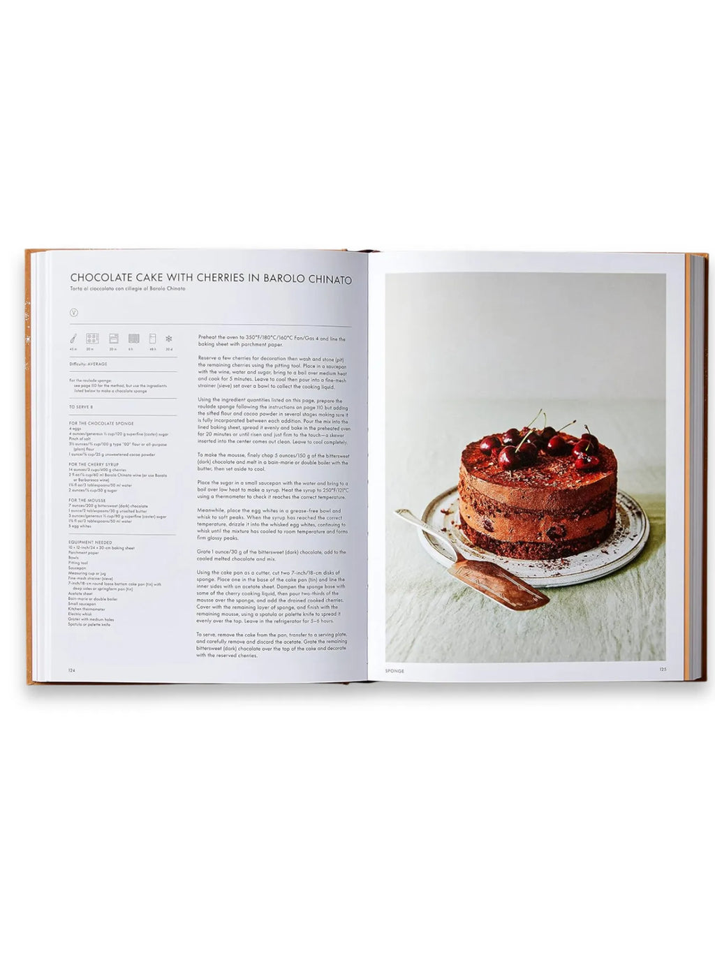 Book The Italian Bakery, open cookbook displaying a "Chocolate Cake with Cherries in Barolo Chinato" recipe, featuring a decadent multi-layered chocolate cake topped with fresh cherries and a silver cake server. This premium cookbook is perfect for home bakers and culinary enthusiasts seeking authentic Italian dessert recipes.