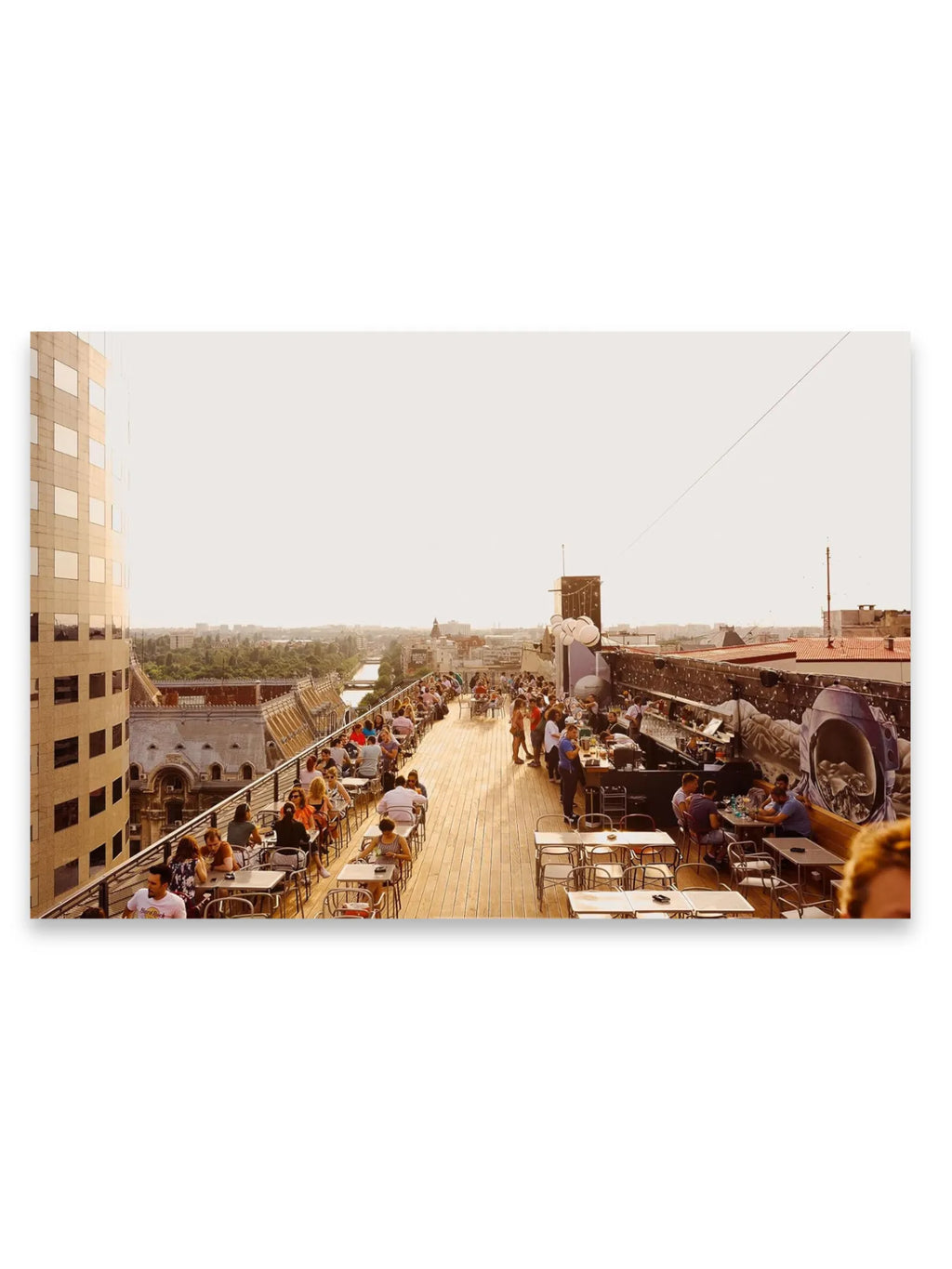 Book The Monocle Guide to Building Better Cities, featuring a vibrant rooftop restaurant scene with diners enjoying an urban cityscape and river view, reflecting modern urban design and lifestyle. This image inspires contemplation on city planning and quality of life, perfect for urban enthusiasts and architectural professionals.