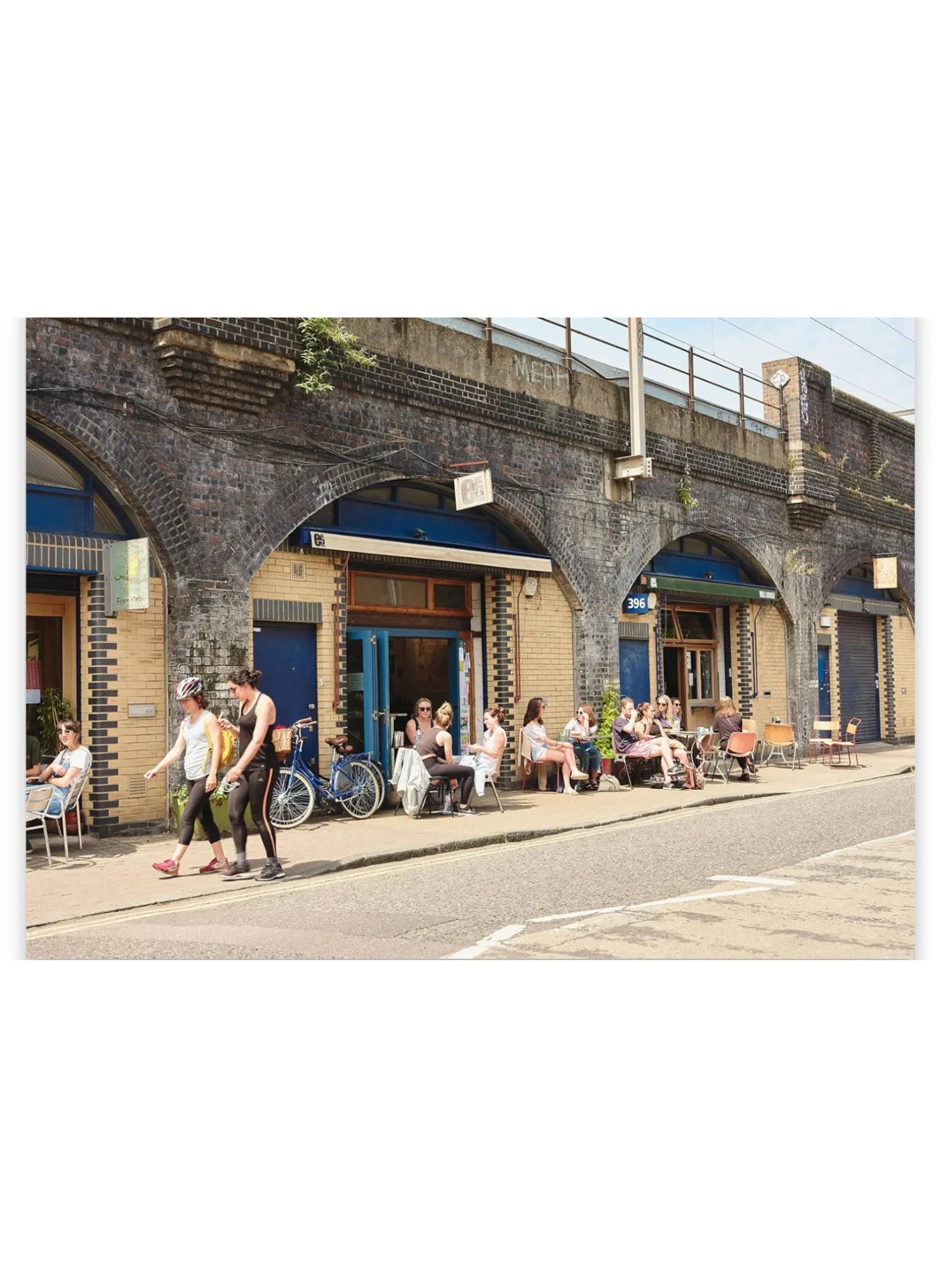 Book The Monocle Guide to Building Better Cities, featuring a vibrant street scene with brick archways, cafes, and people enjoying outdoor seating. This urban planning guide is perfect for professionals, students, and enthusiasts interested in creating more livable and sustainable cities.