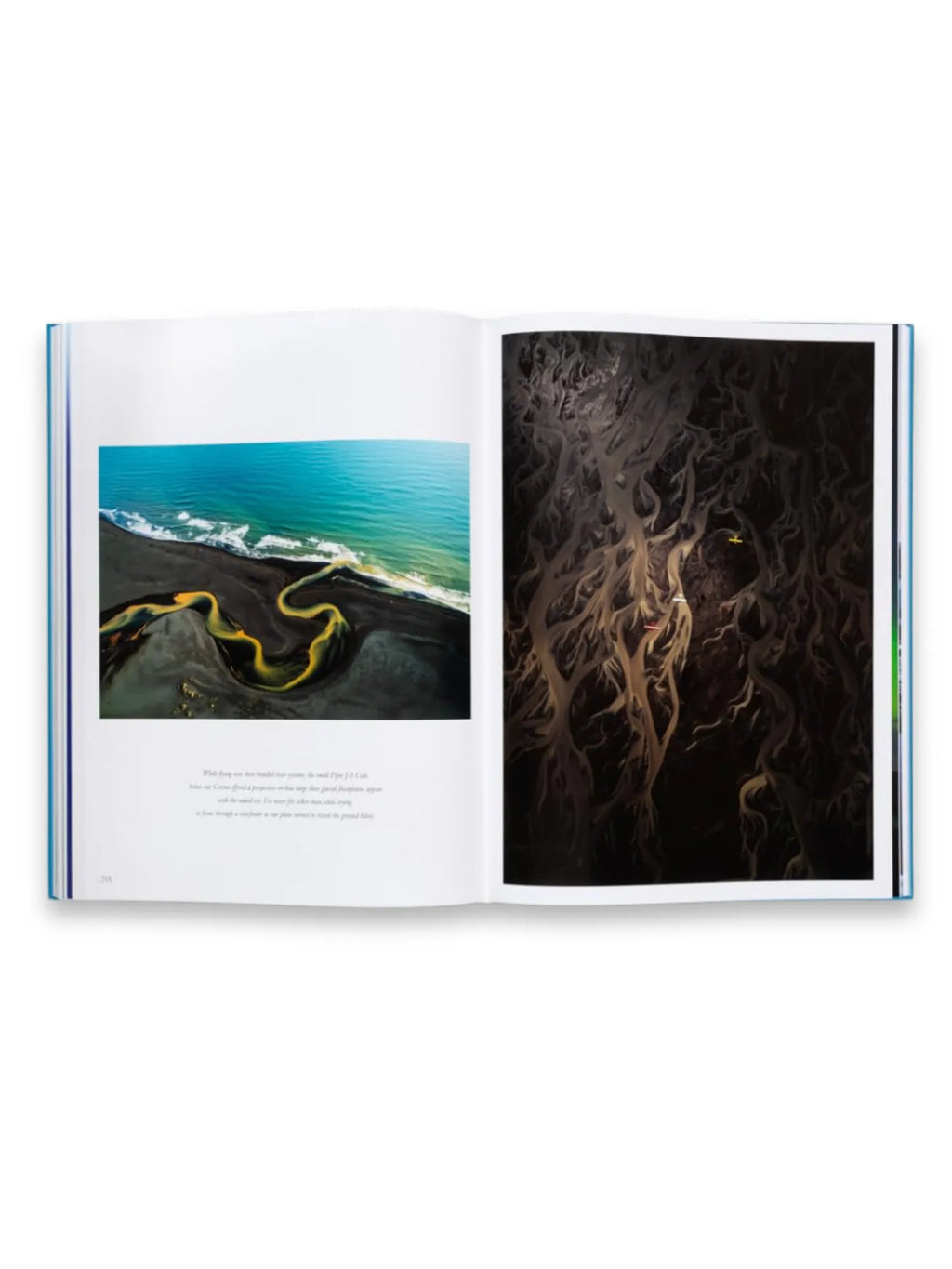 Book The Oceans, an open hardcover book featuring stunning aerial photography of natural landscapes. The left page displays a vibrant blue ocean meeting a black sand beach with a winding golden river, while the right page shows an intricate, dark aerial view of braided rivers or tree roots. This premium coffee table book is ideal for nature enthusiasts and photography lovers.