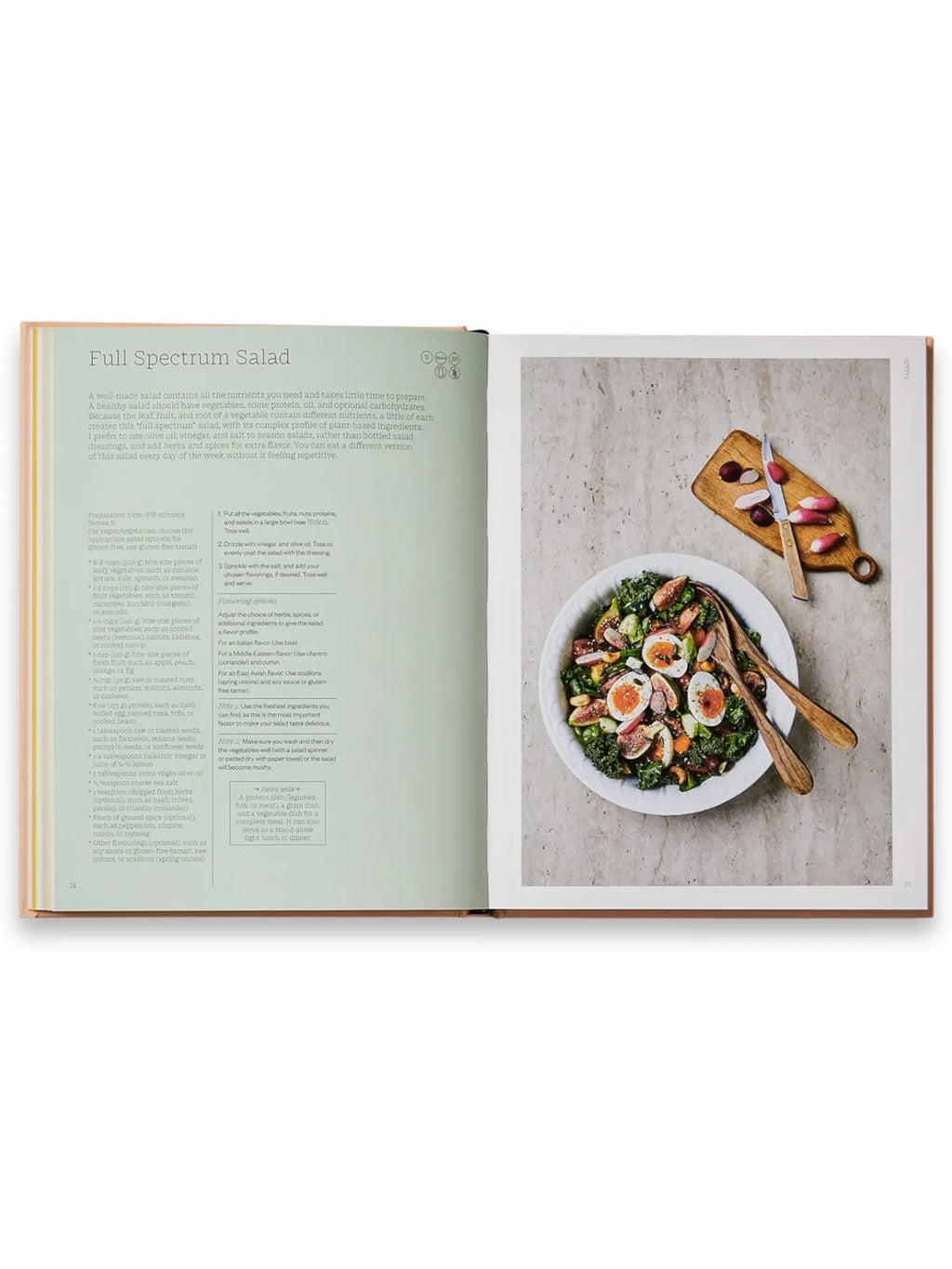 Book The Wellness Principles: Cooking for a Healthy Life, an open hardcover cookbook showcasing a vibrant "Full Spectrum Salad" recipe with kale, figs, eggs, and nuts in a white bowl, alongside radishes on a wooden cutting board with a knife. This essential healthy cooking guide offers delicious, wholesome recipes for wellness-minded food enthusiasts.