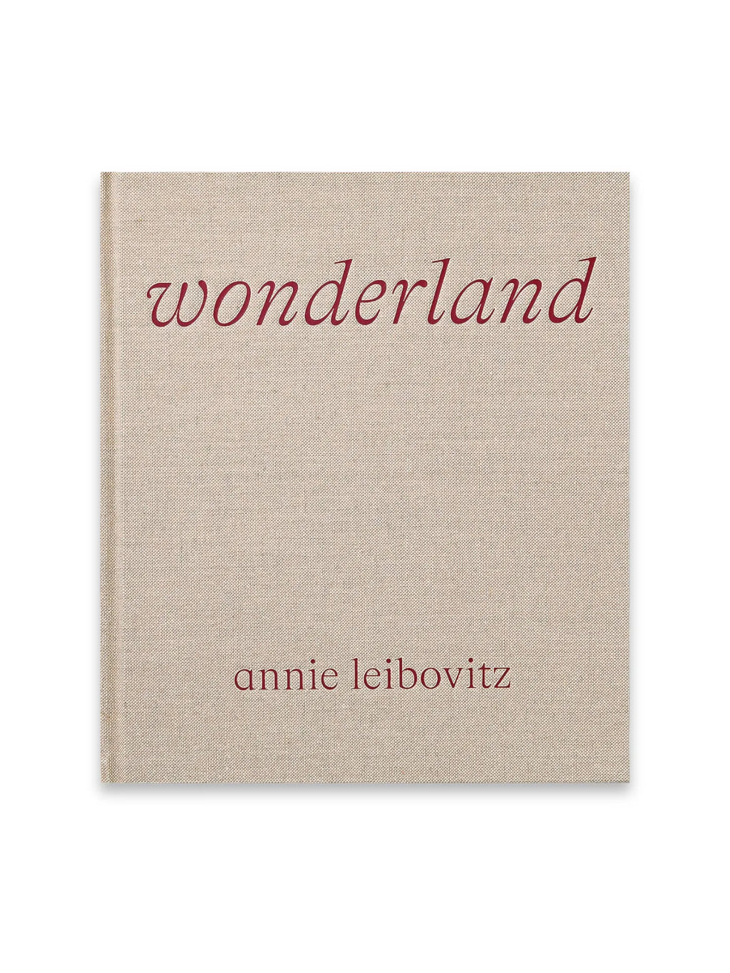 Book Annie Leibovitz’s ‘Wonderland’, a premium hardcover photography book with a light beige linen-textured cover and elegant deep red serif text. This collectible art book is perfect for photography enthusiasts and fans of Annie Leibovitz's iconic work.