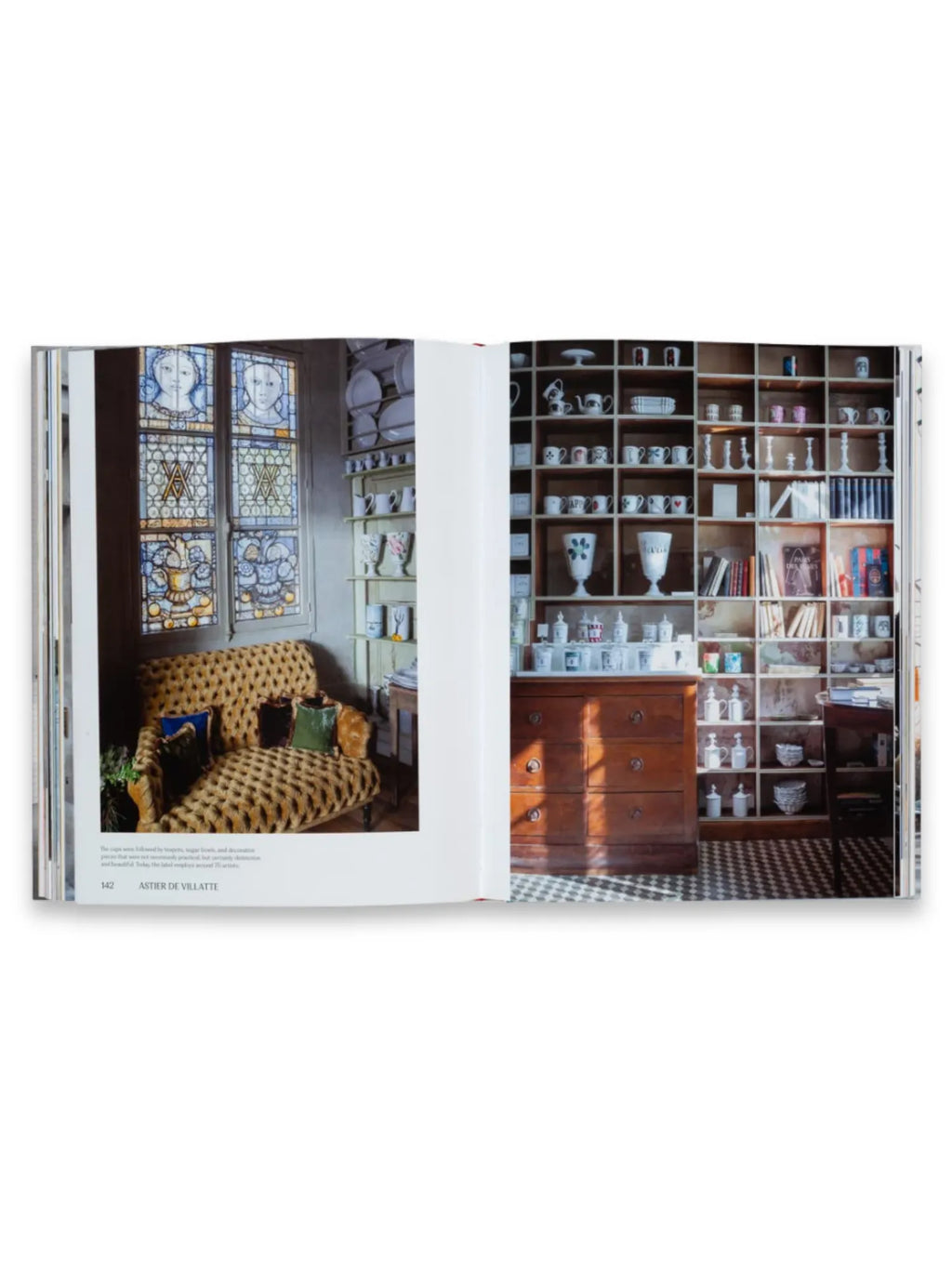 Book Think Big Shop Small, an open coffee table book displaying vibrant interior design photography with stained glass windows, a cheetah print chaise lounge, and a large wooden bookshelf filled with ceramic dishware and decorative objects. This inspiring book is ideal for interior design enthusiasts and anyone seeking creative home decor ideas.