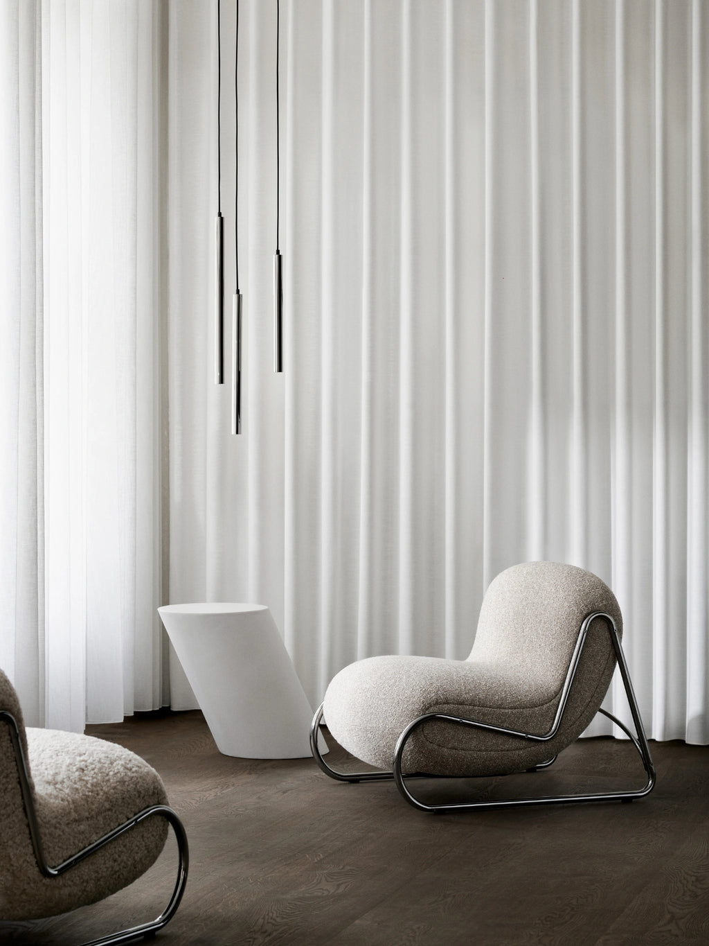NORR11 Tilt Side Table, a modern minimalist accent table with a striking sculptural and geometric silhouette. Crafted from a solid, matte white composite material, its unique tilted cylindrical form offers a smooth, clean finish. Ideal as a contemporary end table for living rooms, a statement piece in entryways, or as a sophisticated bedside table in organic modern interiors.