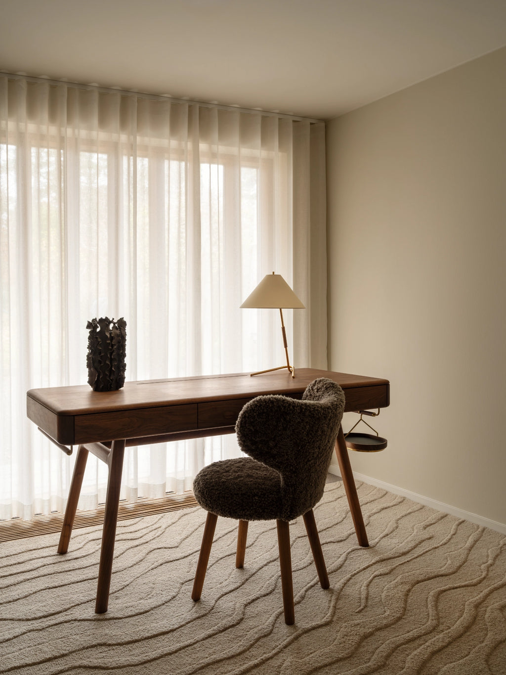 Tinted Objects Duvell Wool Rug, a luxurious cream-colored wool rug featuring an organic, raised wavy pattern. This elegant area rug adds texture and warmth to any modern living space or home office.