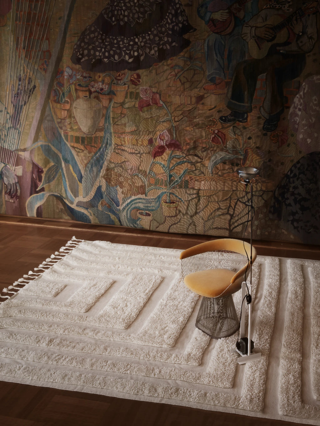 Tinted Objects Kask Wool Rug, a luxurious off-white hand-tufted wool rug with a raised geometric pattern and fringed ends. This stylish floor covering adds warmth and texture to modern living spaces for homeowners seeking elegant home decor.