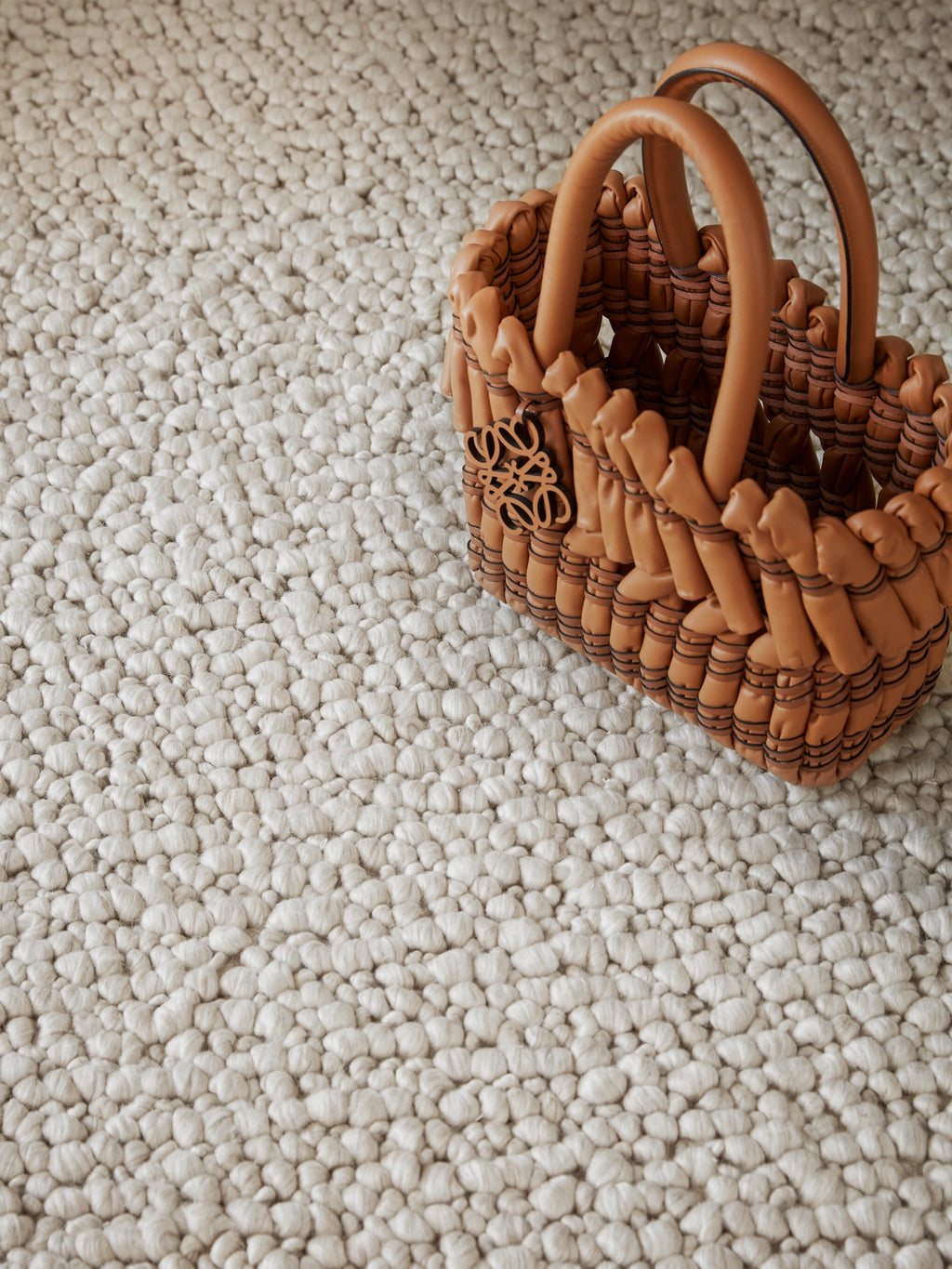 Tinted Objects Andersdotter Wool Rug, a luxurious light beige wool rug with a unique, textured pebble-like knot design. This stylish and durable area rug is perfect for adding warmth and sophisticated elegance to modern living rooms or bedrooms.