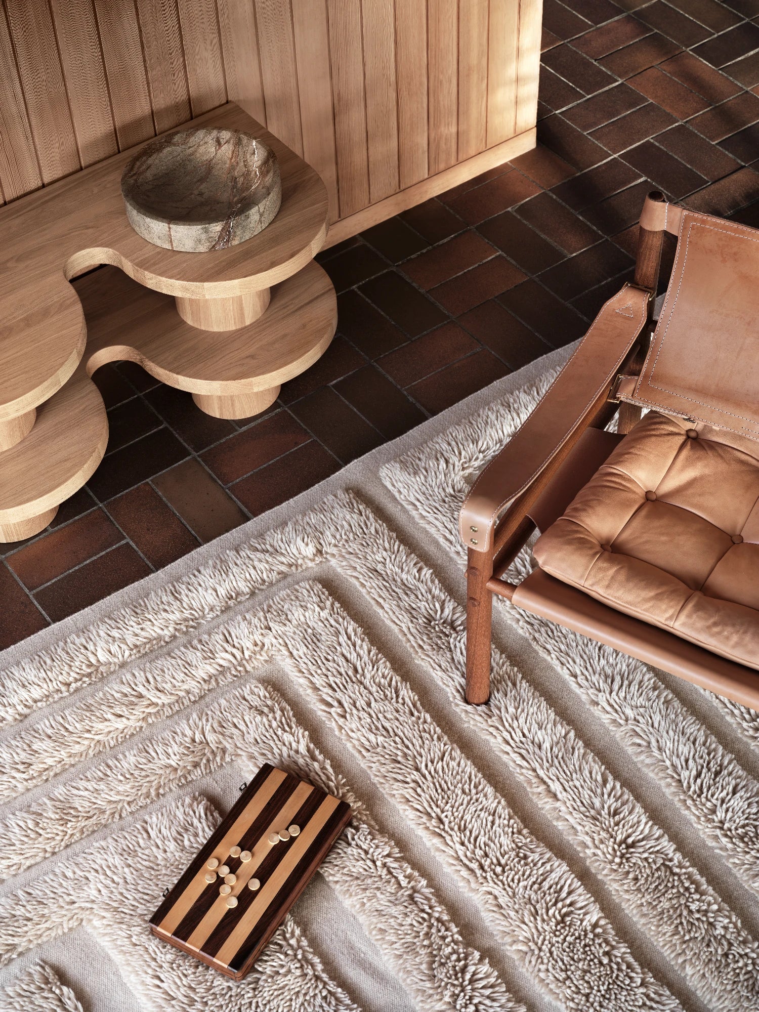 Tinted Objects Kask Wool Rug, a luxurious cream-colored textured area rug with alternating stripes of plush shag and flat weave. This stylish and comfortable floor covering is perfect for adding warmth and sophisticated design to modern living spaces.