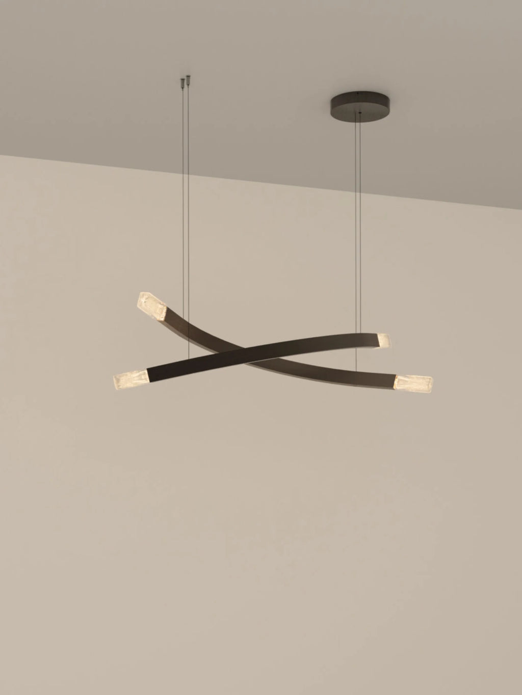 CTO Lighting Trace Linear X Chandelier, a modern minimalist pendant lamp featuring three intersecting curved arms in a matte black metal finish with integrated LED light sources diffused through clear, textured crystal. This sculptural linear ceiling light creates a striking visual statement, suspended elegantly by fine wires. Ideal as a contemporary dining room chandelier, living room accent light, or sophisticated lighting solution for modern luxury interiors.