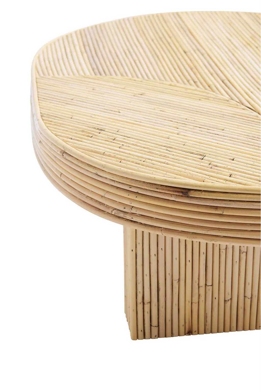Tine K Viva Rattan Table, an organic modern oval coffee table crafted from natural light-toned rattan poles, featuring a distinctive reeded texture and a chevron pattern on its rounded tabletop. The sturdy base is also composed of vertical rattan reeds, creating a cohesive, natural aesthetic. Ideal for bohemian, coastal, or contemporary living rooms seeking a touch of warmth and organic design.