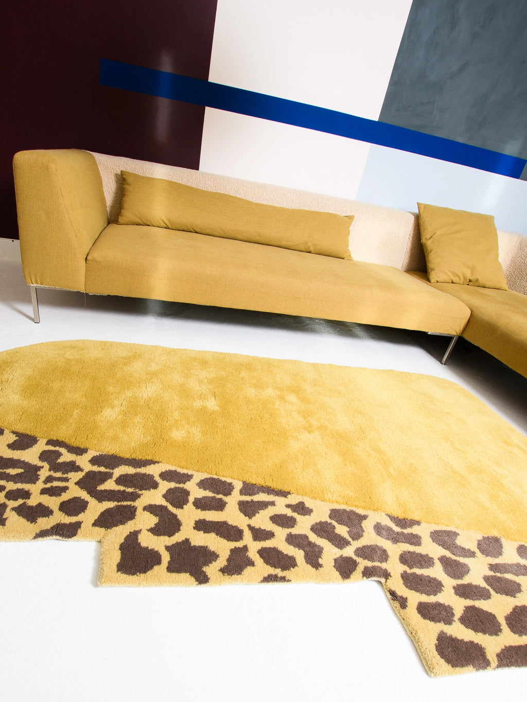 Haus Üger Wild Mist Rug, a maximalist area rug featuring a plush mustard yellow pile with an irregular, organic shape, partially adorned with a bold dark brown leopard spot pattern.