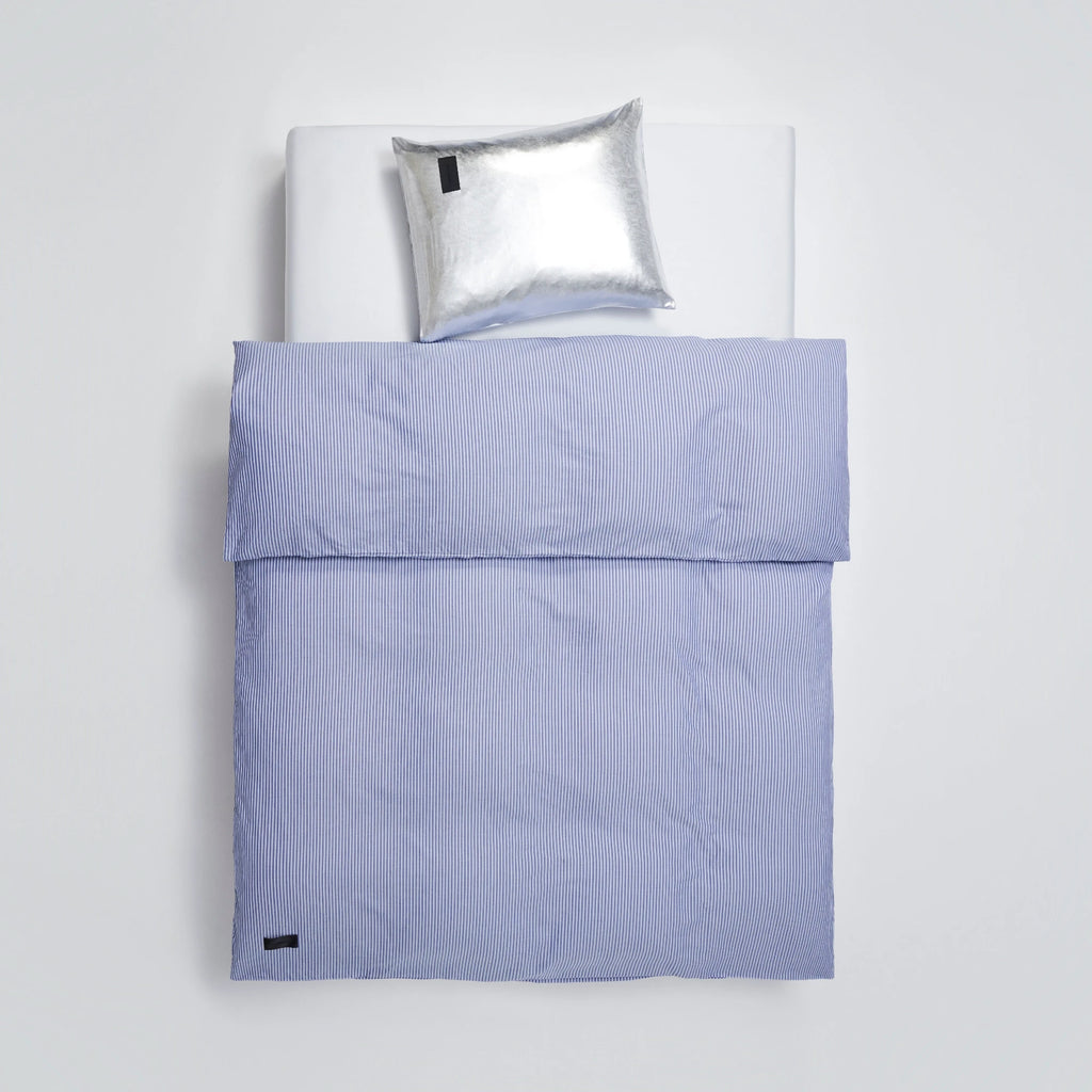 Magniberg Wall Street Duvet Cover - Stripe Dark Blue Oxford, a classic dark blue and white striped duvet cover crafted from crisp cotton oxford fabric, featuring a refined vertical pinstripe pattern and a small black brand label. This tailored bedding is perfect for creating a sophisticated, modern minimalist, or classic preppy bedroom aesthetic.