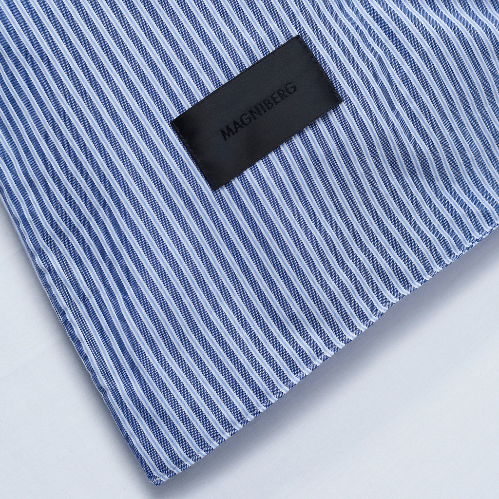 Magniberg Wall Street Duvet Cover - Stripe Dark Blue Oxford, a crisp cotton Oxford duvet cover featuring a classic pinstripe pattern in alternating dark blue and lighter blue hues with fine white lines, creating a textured woven fabric finish. This sophisticated bedding offers a timeless and modern minimalist aesthetic for a stylish bedroom decor.